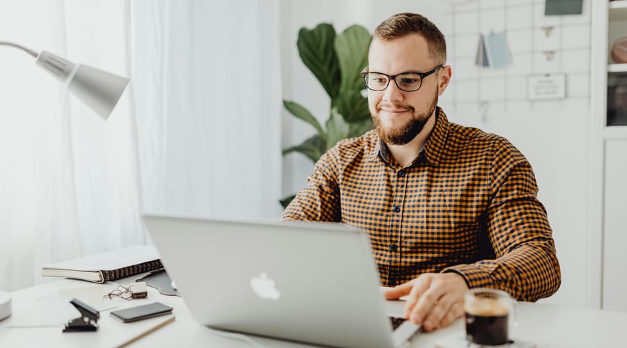Hombre estudiando con su computadora porque cree en la educación en línea.
