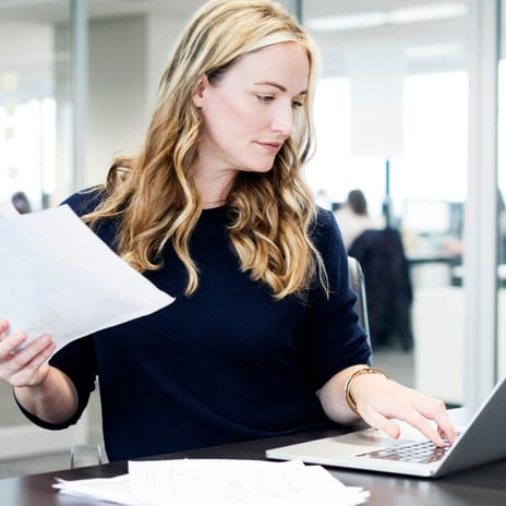 Mujer en la oficina trabajando mientras practica el inglés.