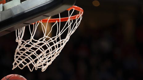 Balón de basketball encestado en la canasta