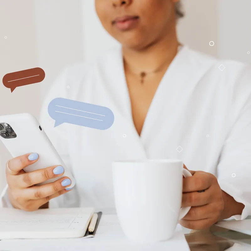 Una mujer con una taza blanca, viendo en su celular un artículo sobre reglas gramaticales nuevas.