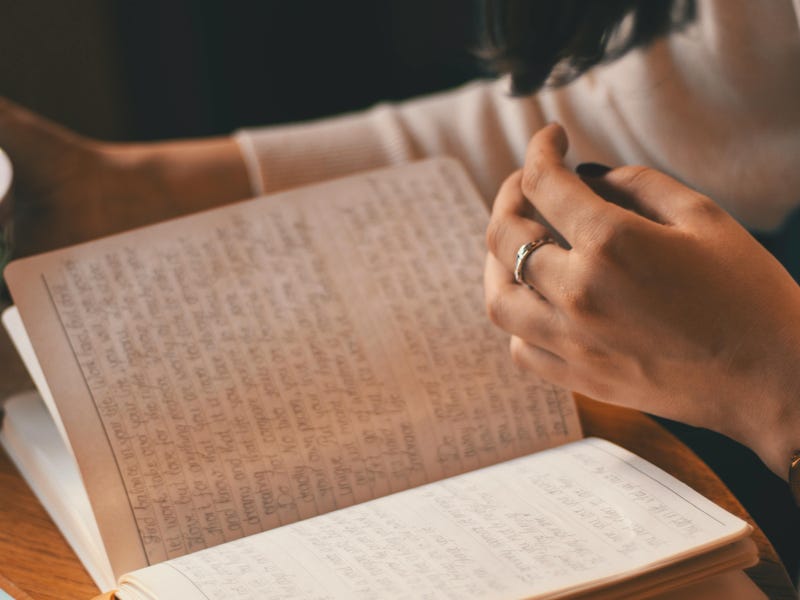 Mujer estudiando cómo crear oraciones positivas en inglés en su cuaderno.
