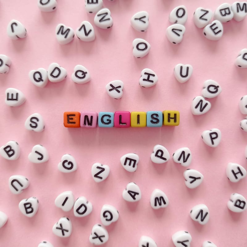 La palabra “English” formada por letras en desorden sobre un fondo rosa.