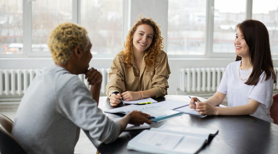 Tres amigos estudiando juntos los adverbios de lugar en inglés.