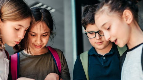 niños mirando notas