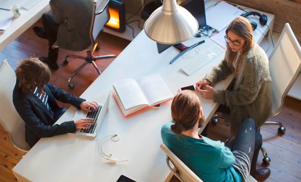 Hombre preguntando en una oficina a una mujer asesora de Bertliz sobre los servicios de enseñanza de idiomas de Bertliz y su método.