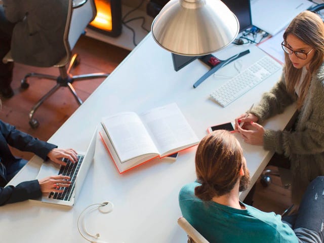Hombre preguntando en una oficina a una mujer asesora de Bertliz sobre los servicios de enseñanza de idiomas de Bertliz y su método.