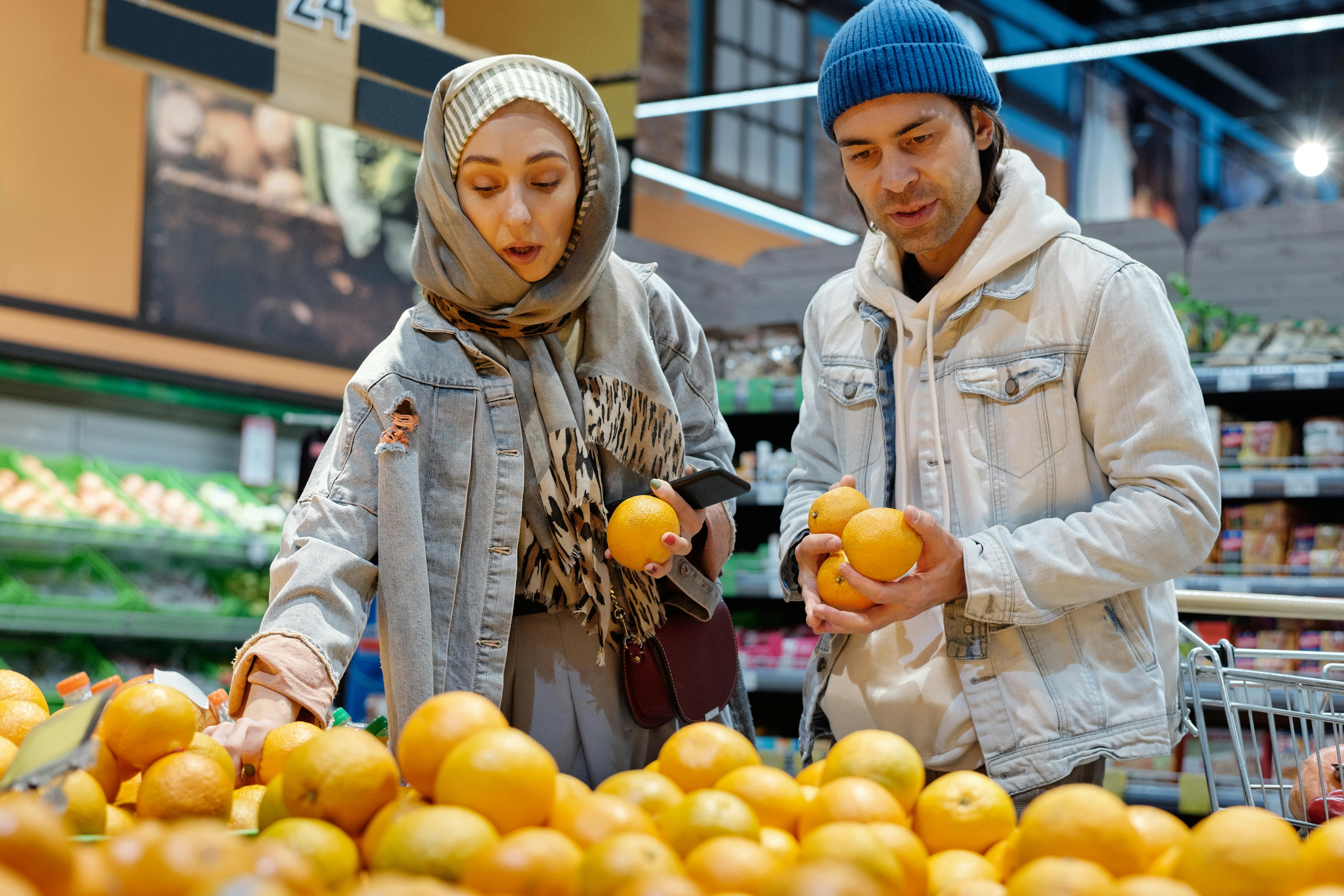 Pareja en el mercado buscando frutas.
