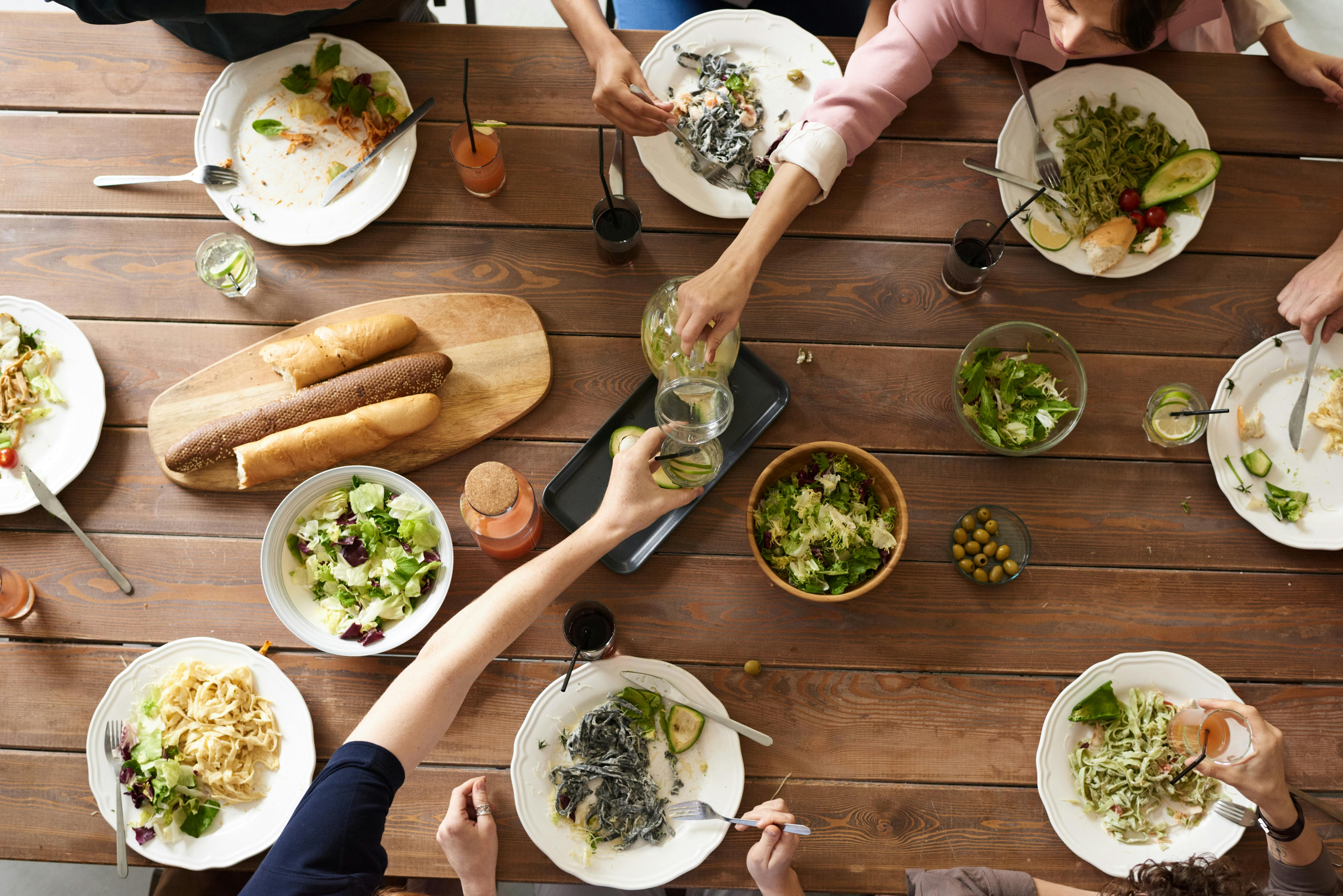 Los amigos se reúnen para almorzar mientras hablan de comida en inglés.