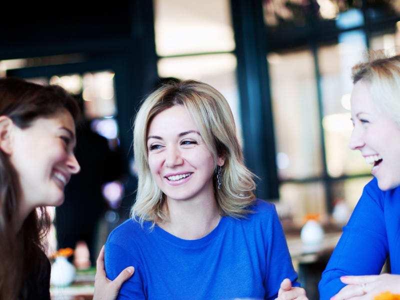 Tres mujeres en una cafeteria hablando
