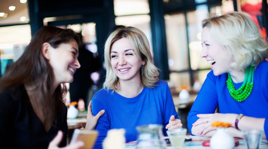 Tres mujeres en una cafeteria hablando