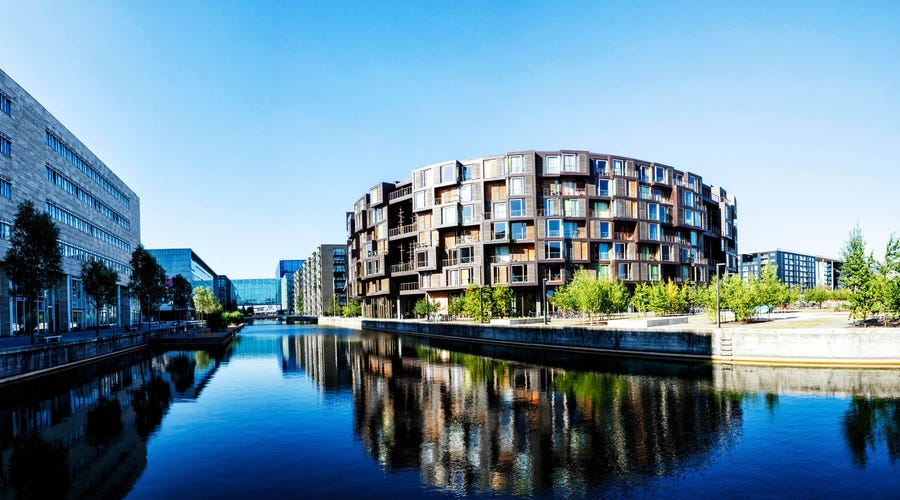 escenario de un edificio y su reflejo junto a un cuerpo de agua 