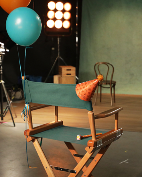 Directors chair with birthday hat and balloons