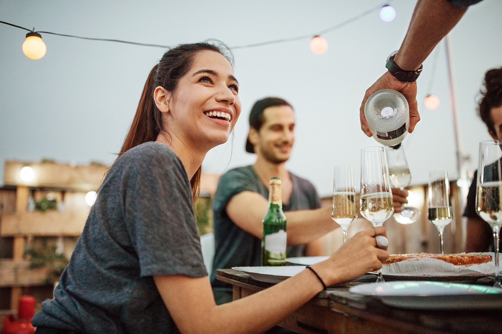Woman in a party drinking wine and saying Hi to the waiter in German