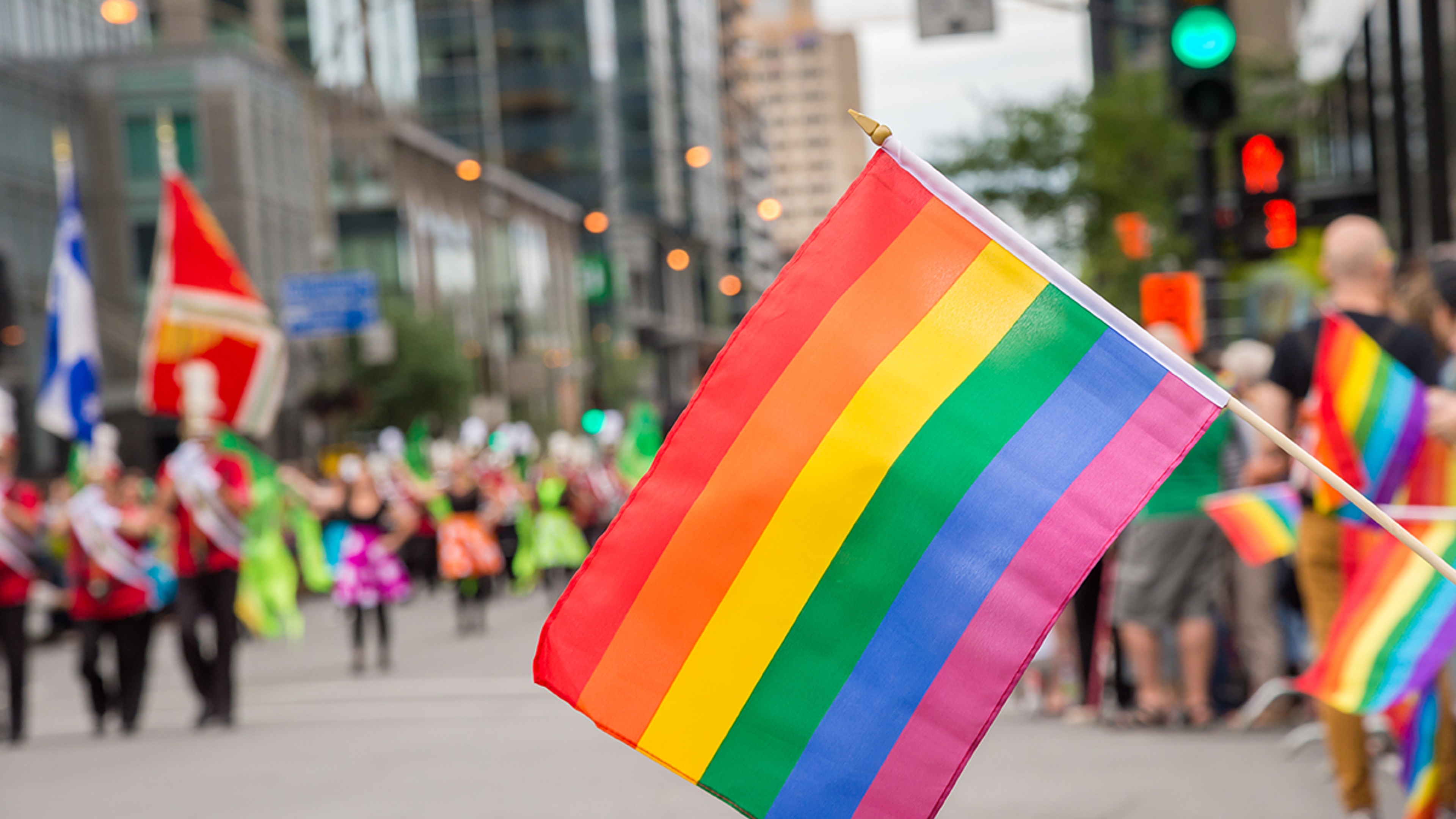 Gay rainbow flags at Montreal gay pride parade with blurred spectators in the background