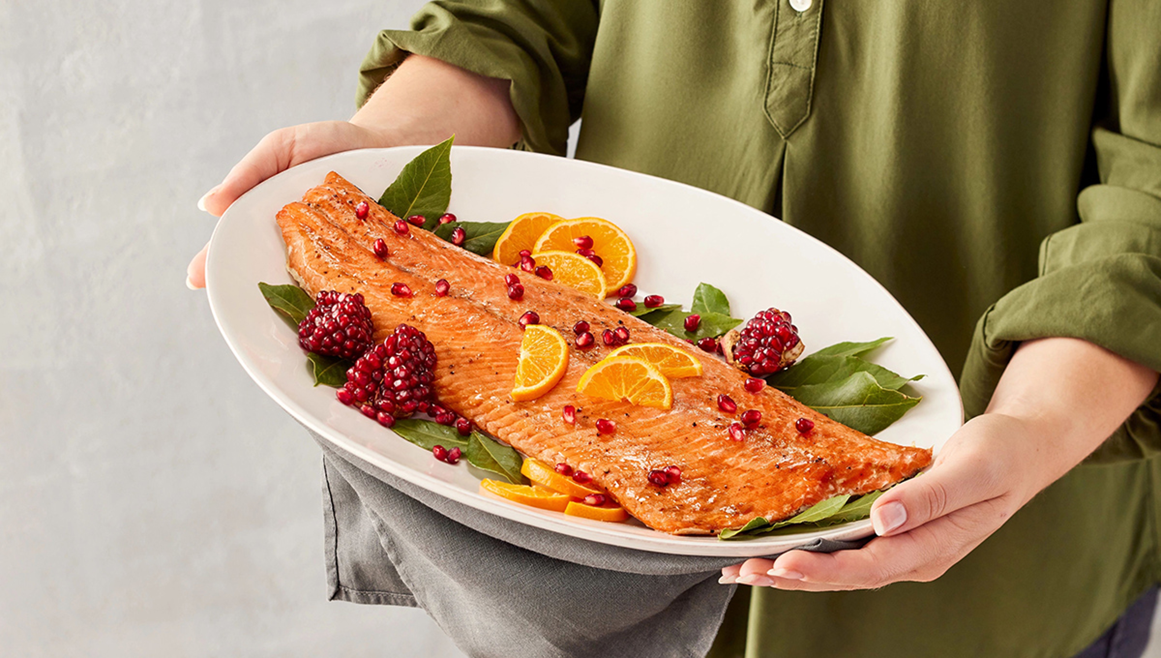 Article Cards Featured Image mediterranean menu woman holding platter cooked salmon hero