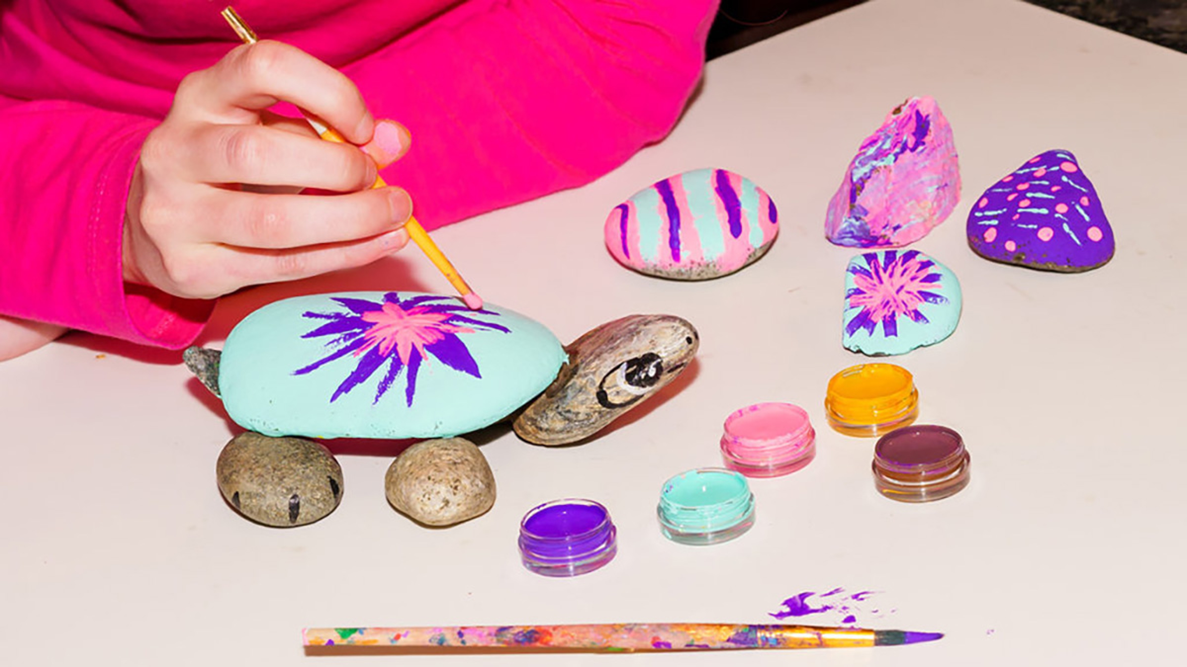 Kid painting rocks at a birthday party.
