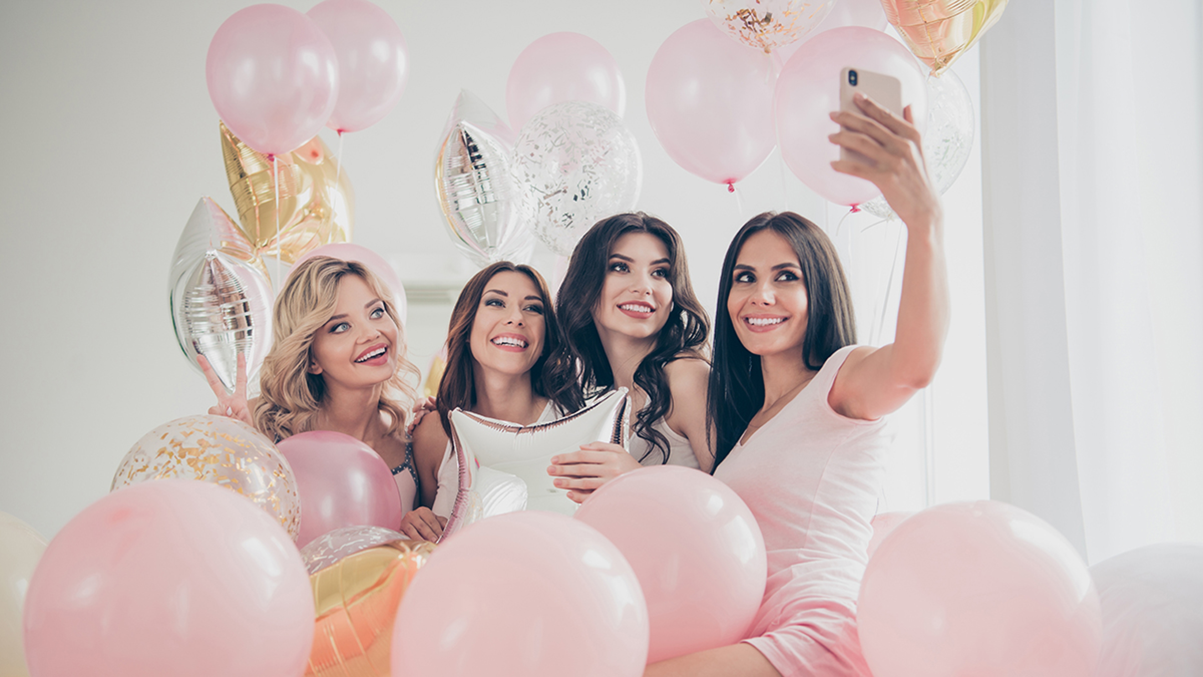 Article Cards Featured Image Portrait of nice cute lovely attractive charming cheerful glad girlfriends making taking selfie hugging baloon having fun in light white interior decorated house indoors