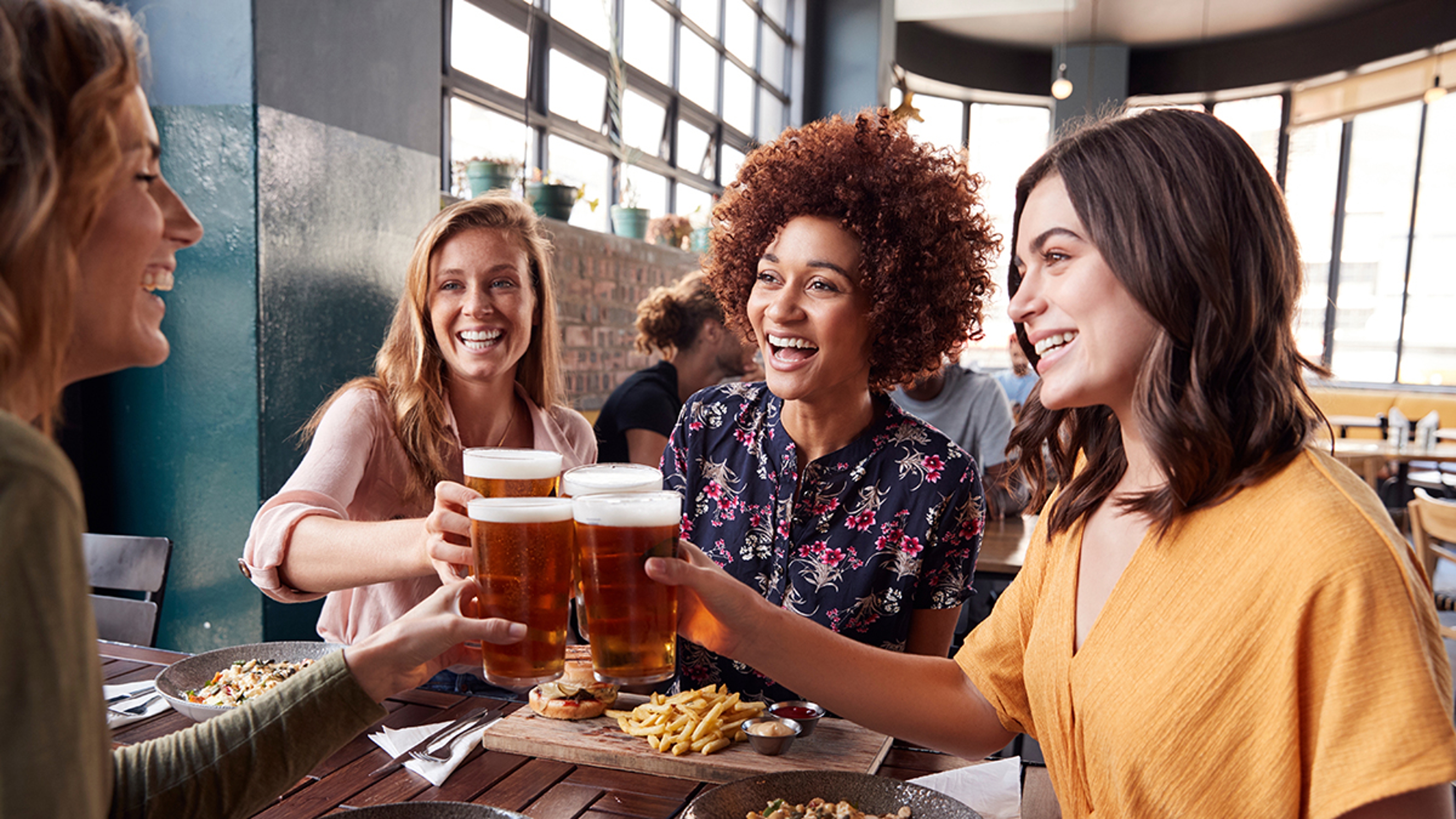 Article Cards Featured Image Four Young Female Friends Meeting For Drinks And Food Making A Toast In Restaurant