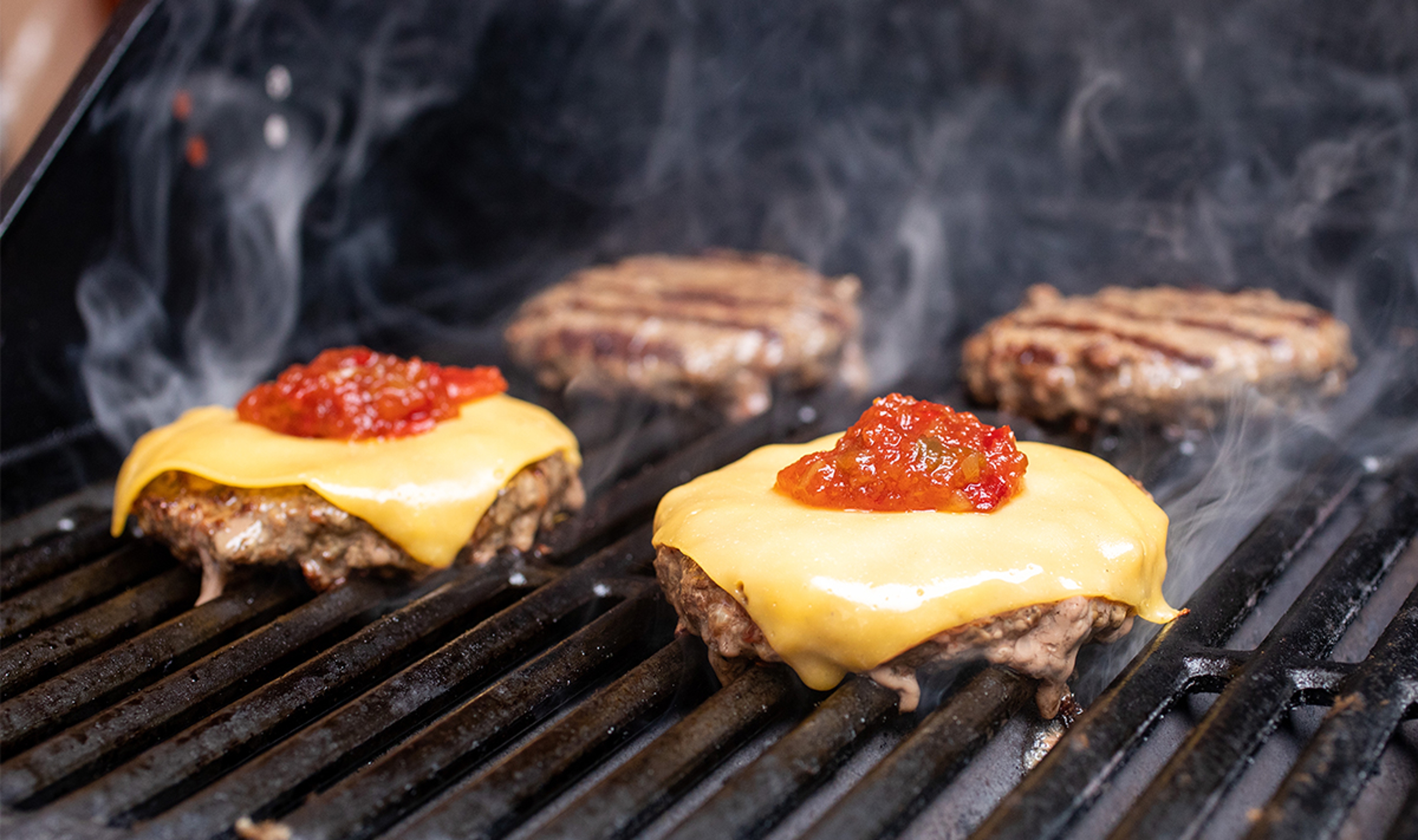 Article Cards Featured Image grilling burgers with cheese and relish