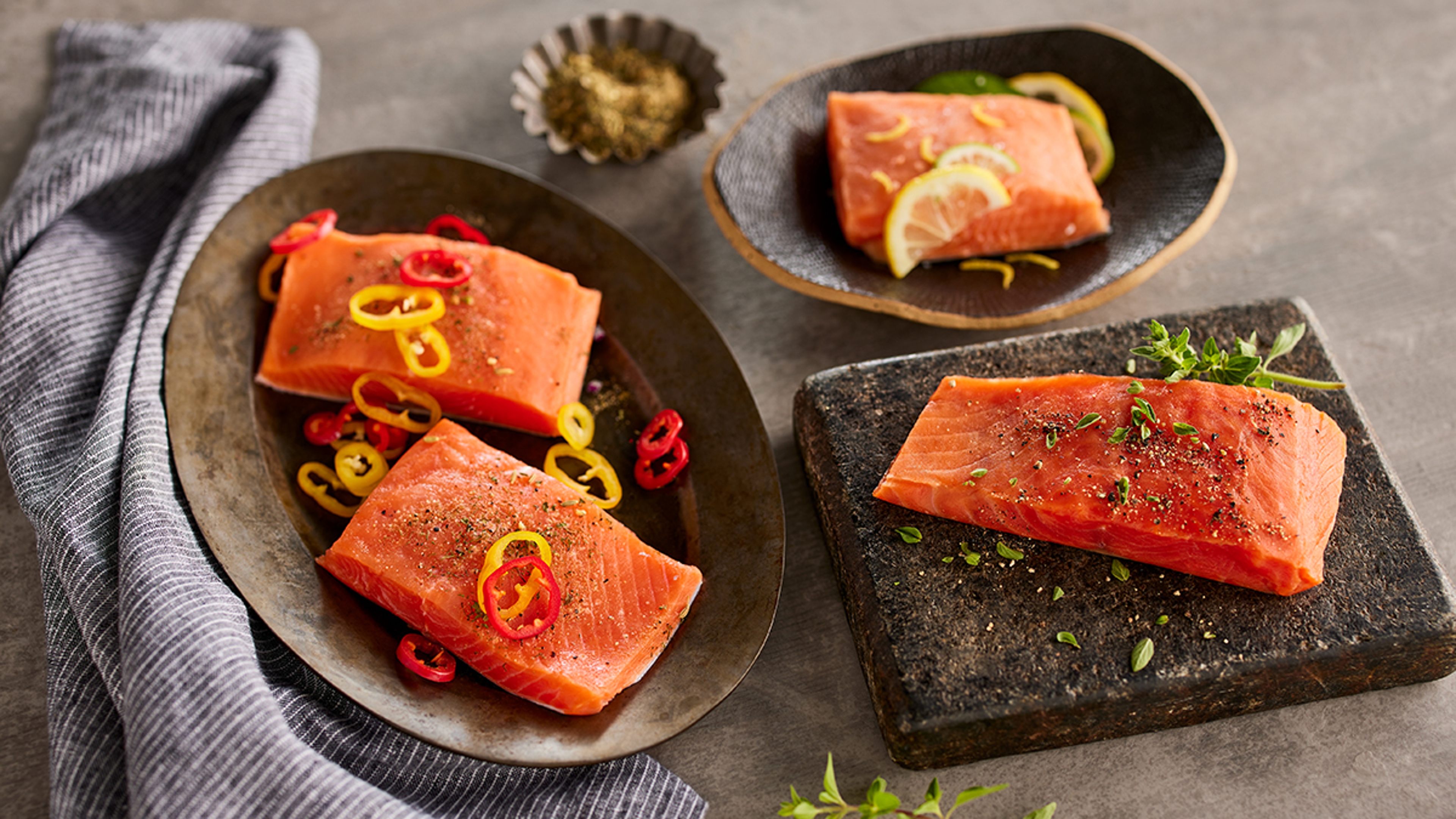 Four cooked salmon fillets on plates.