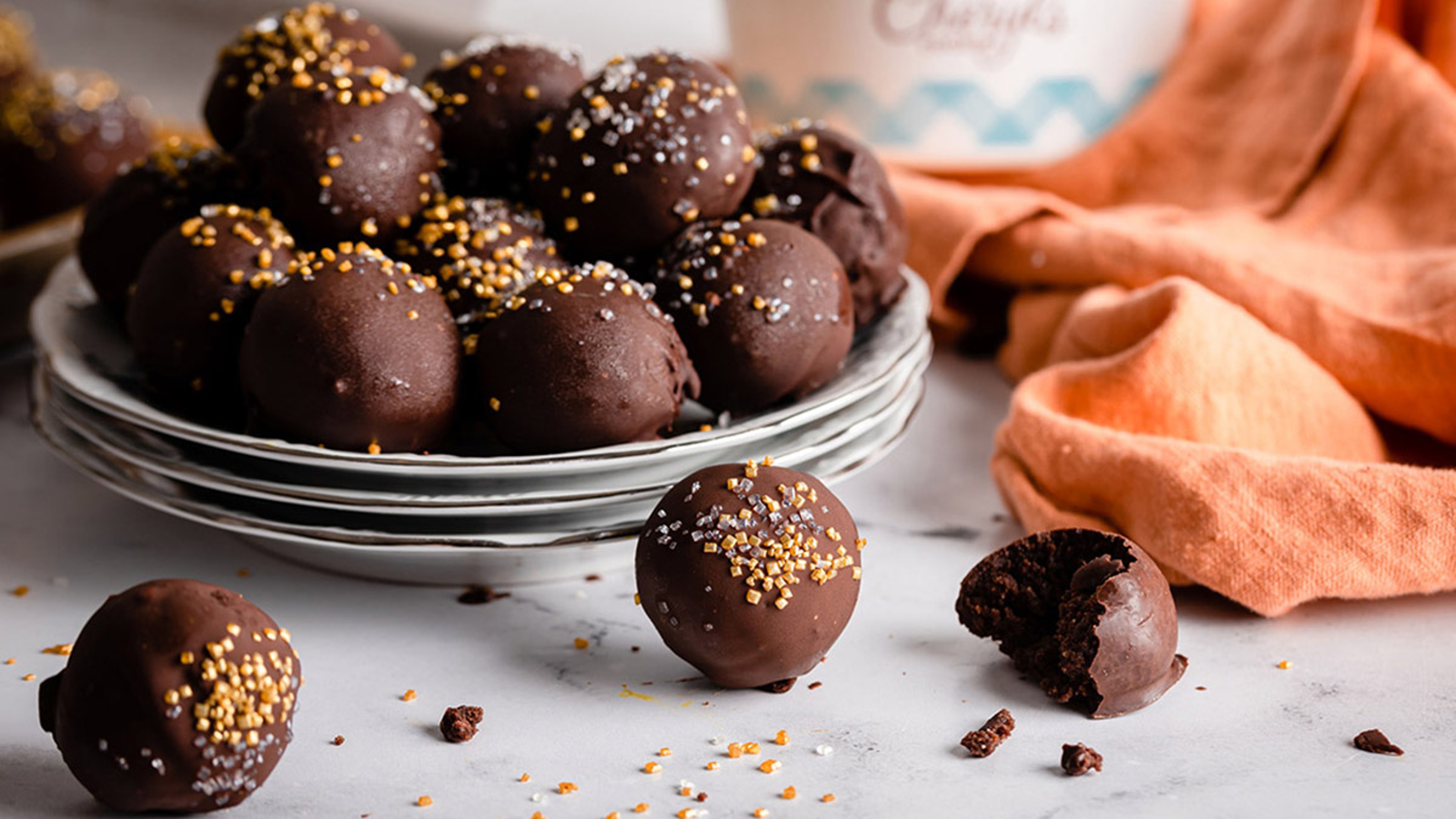 Close up of chocolate cake balls on plates covered in sprinkles