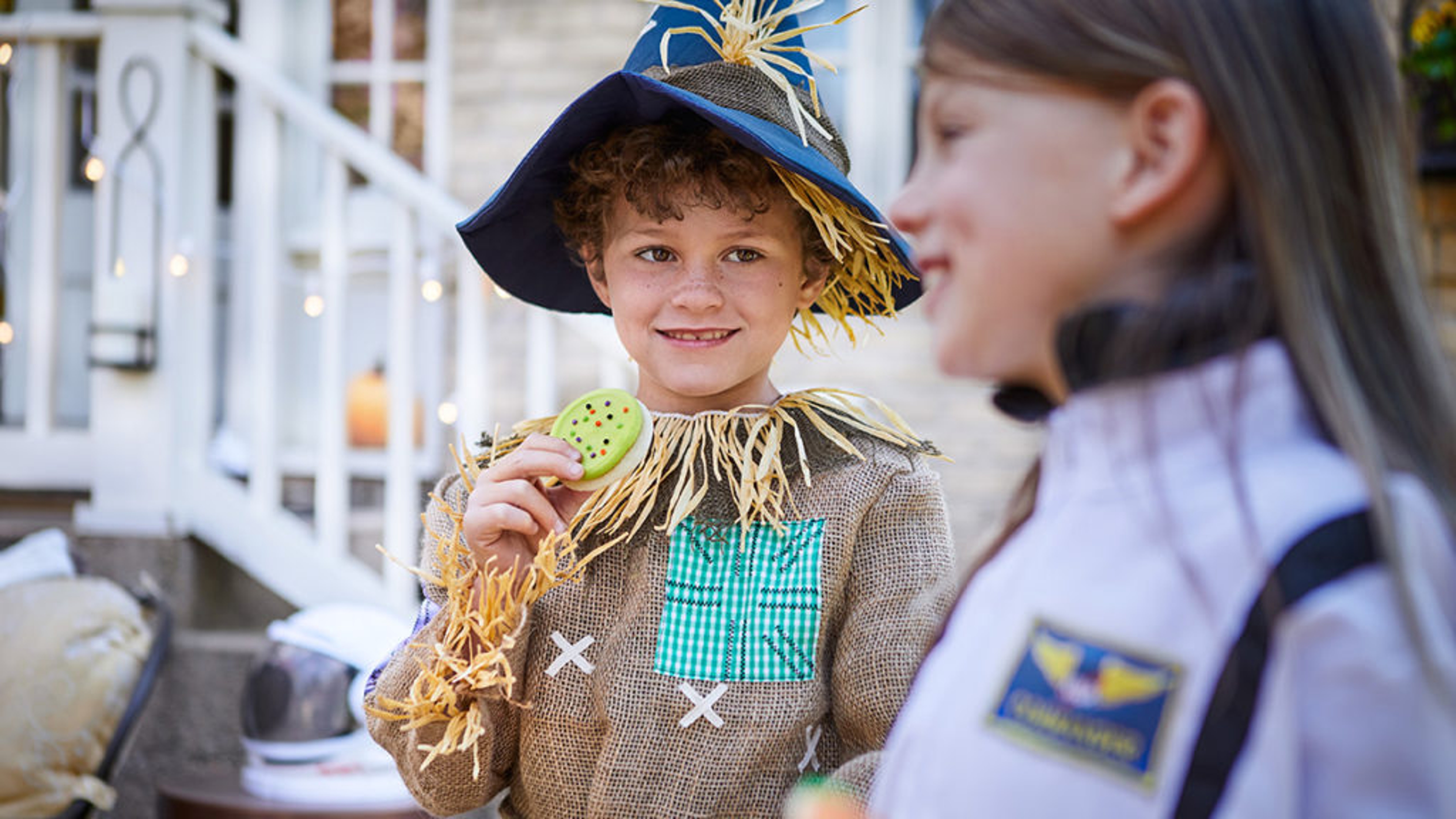 fall birthday party ideas image child dressed as a scarecrow eating a cookie
