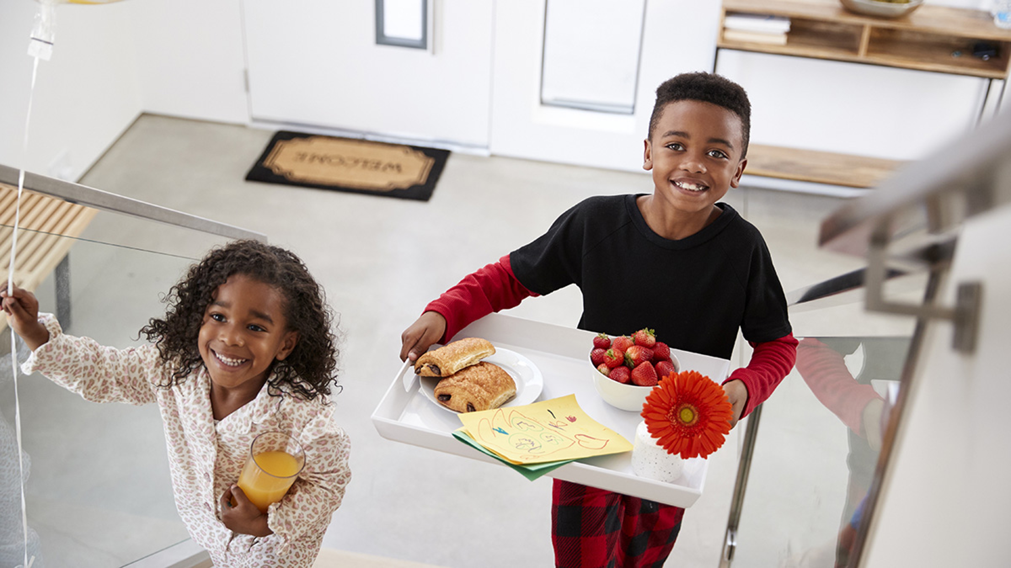 Children Bringing Parents Breakfast In Bed On Tray To Celebrate Birthday Mothers Day Fathers Day