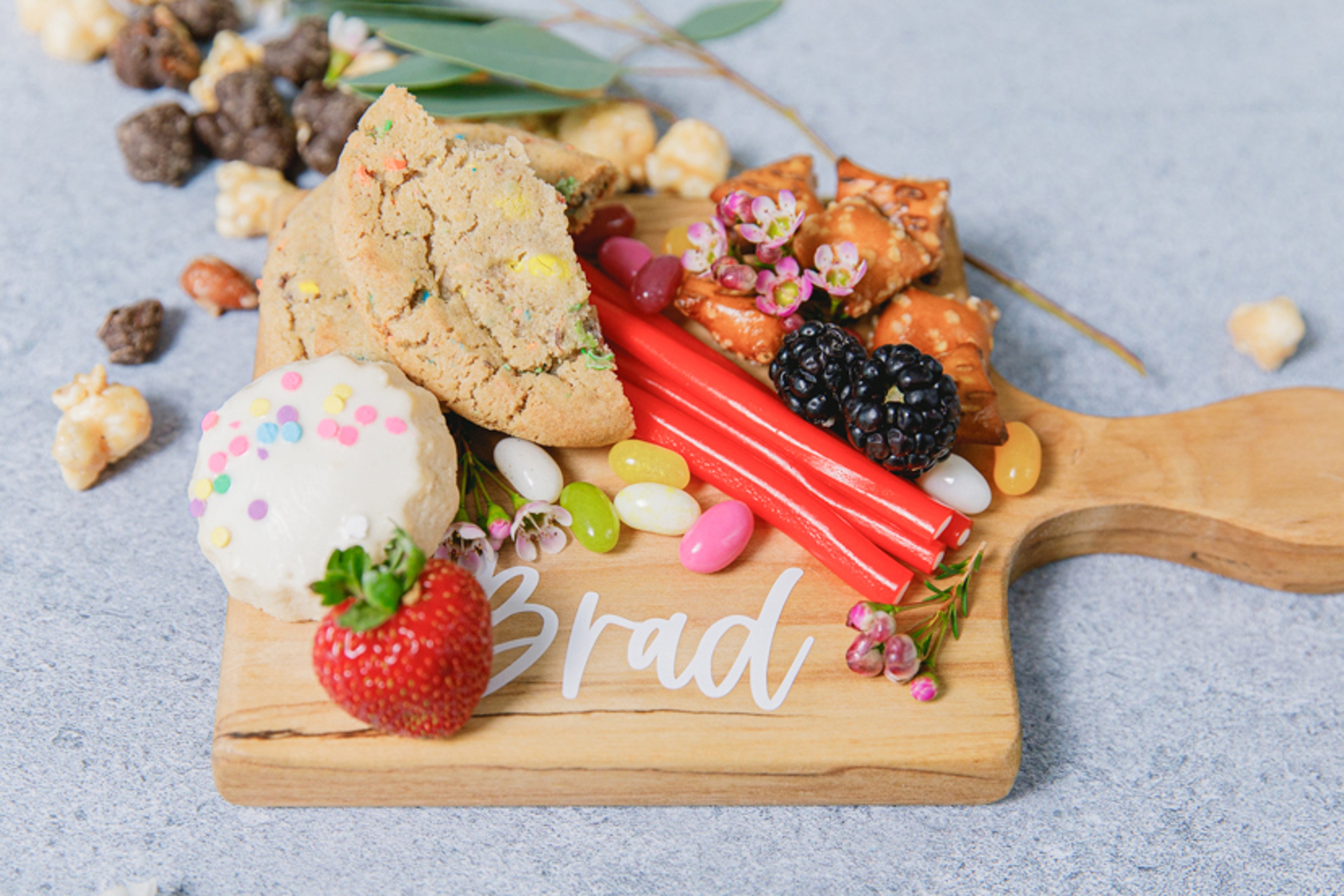 Host a movie night with a closeup of a personalized snack board with cookies and fruit.