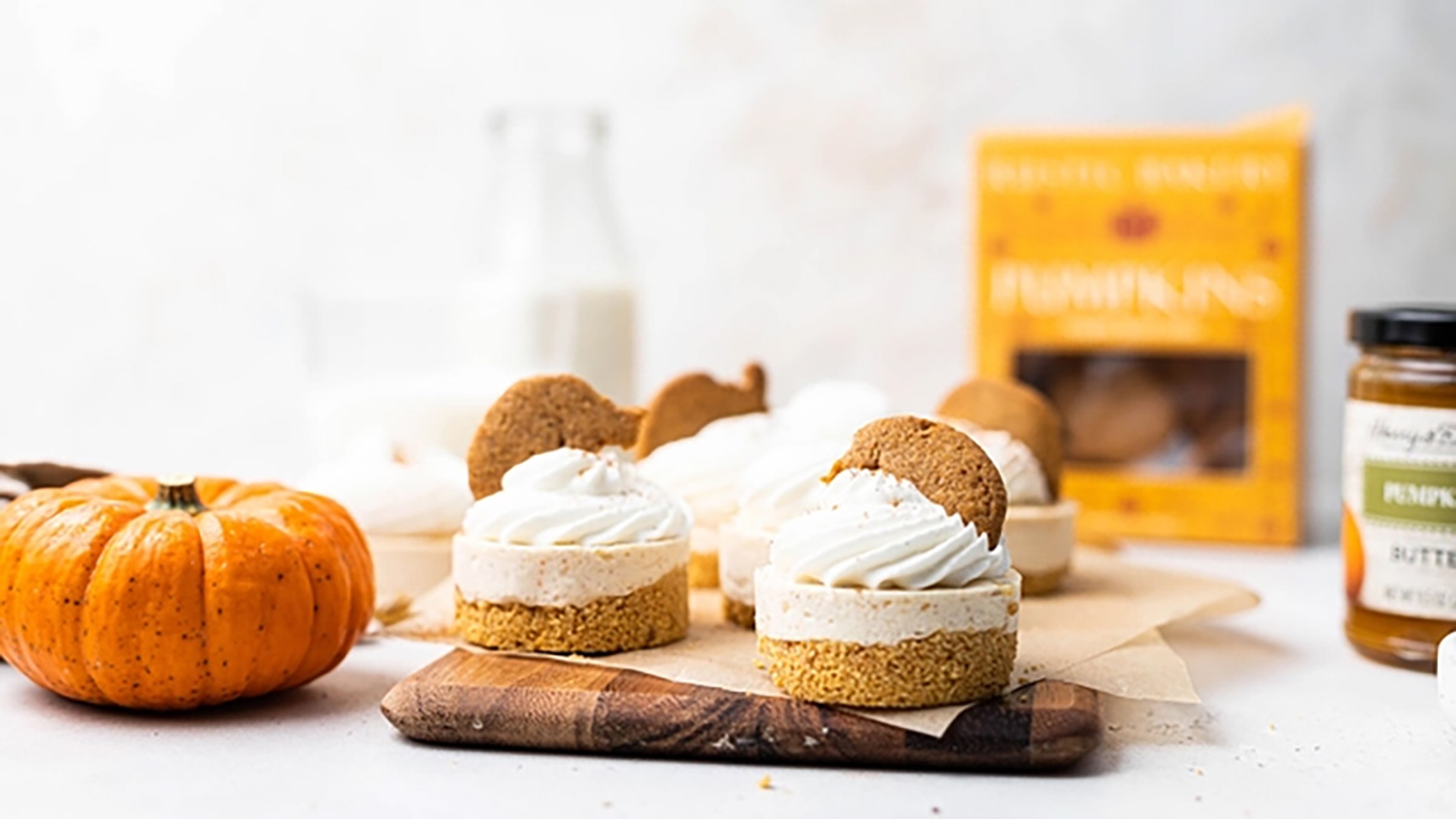 Individual pumpkin cheesecakes on a cutting board.