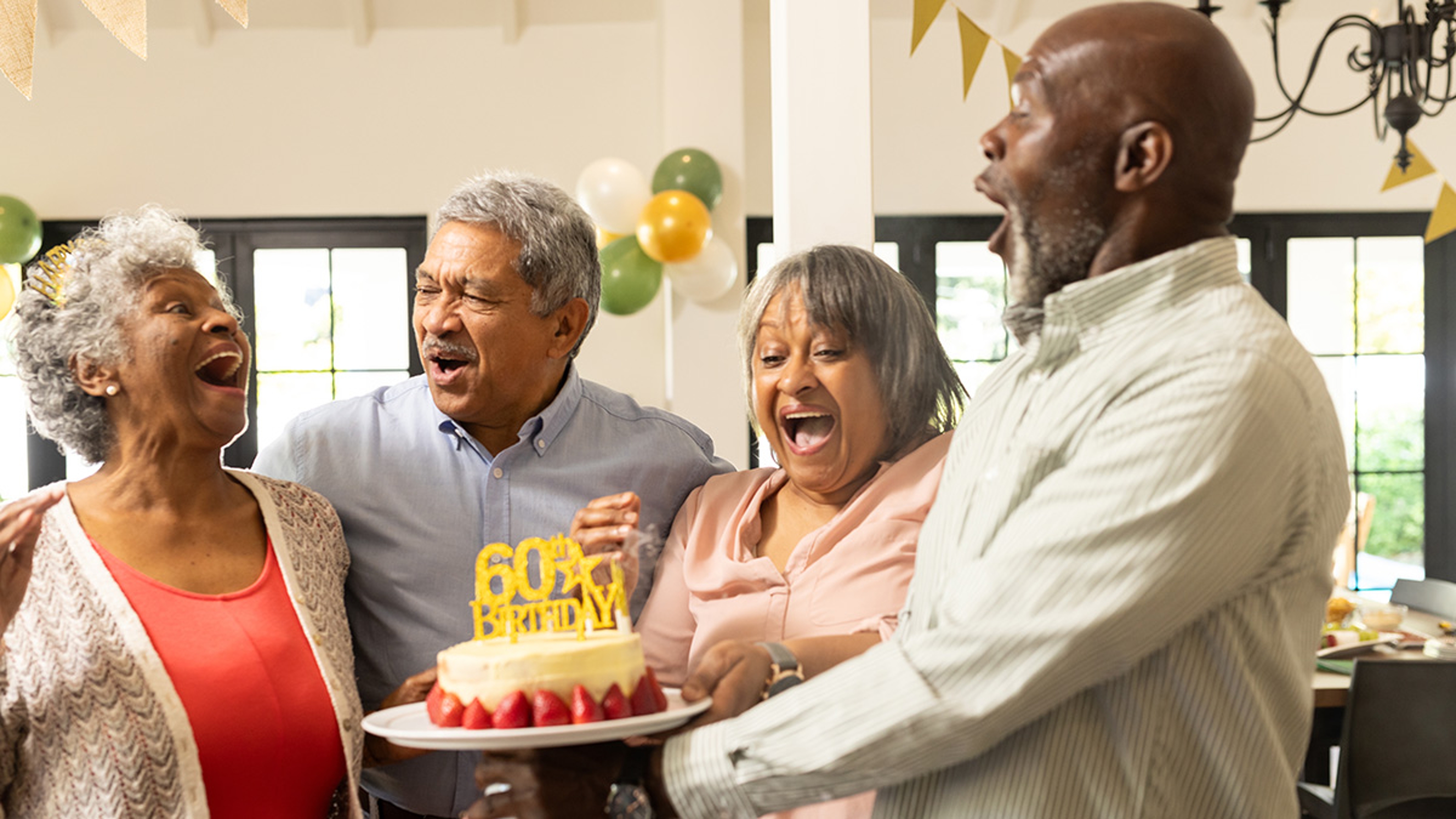 Group of adults singing happy birthday to each other.