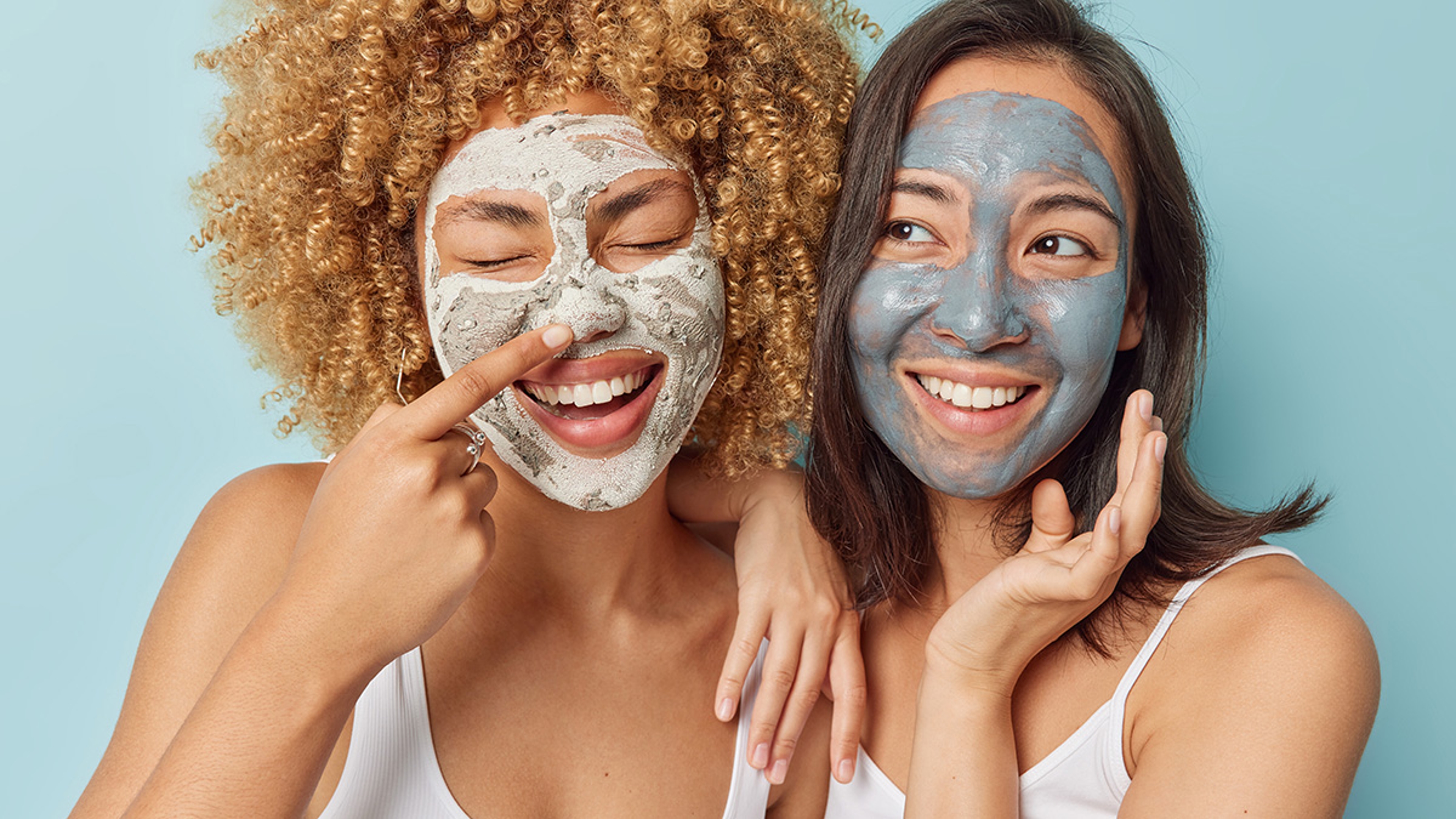 Two women with clay face masks.