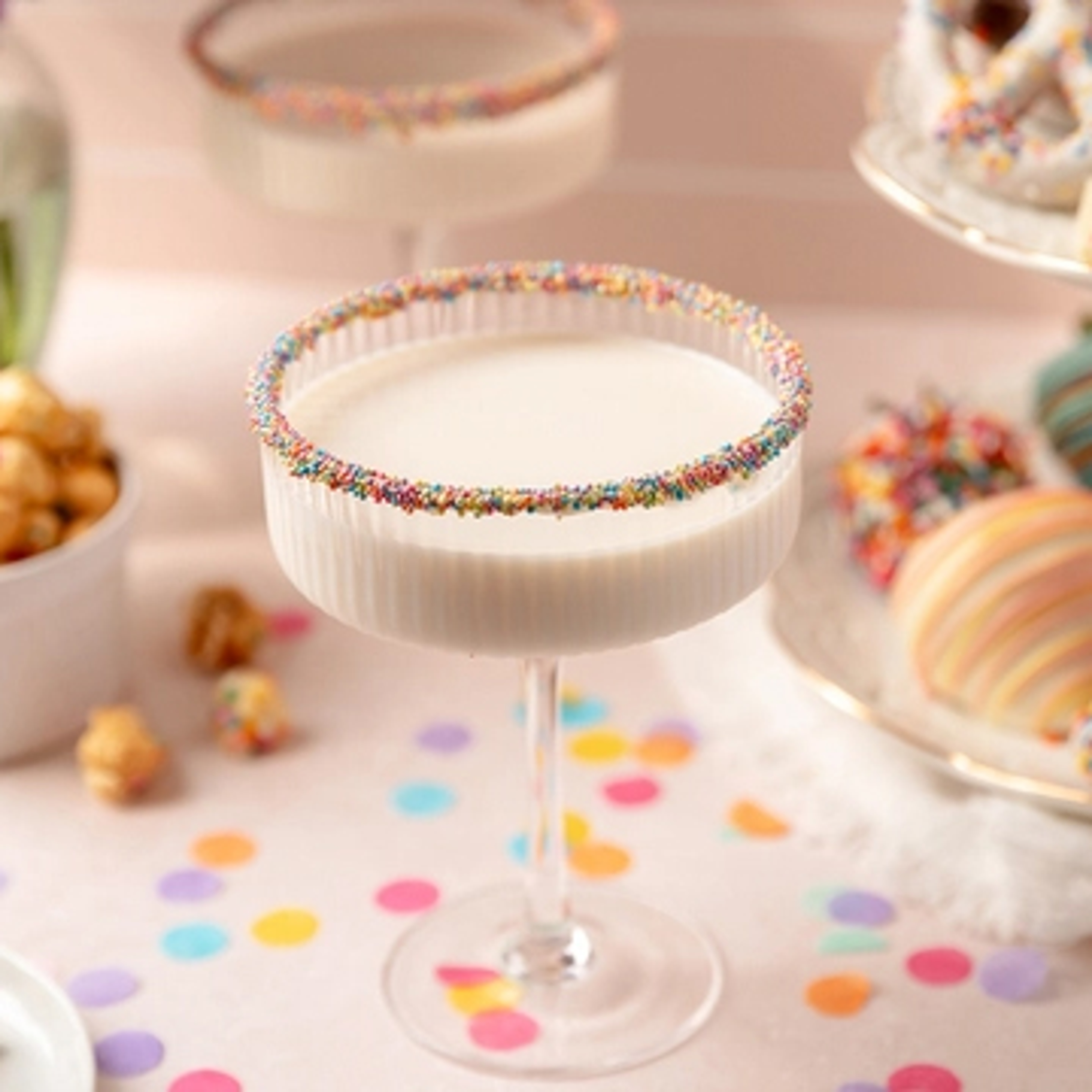 Birthday cake martini surrounded by birthday decorations.