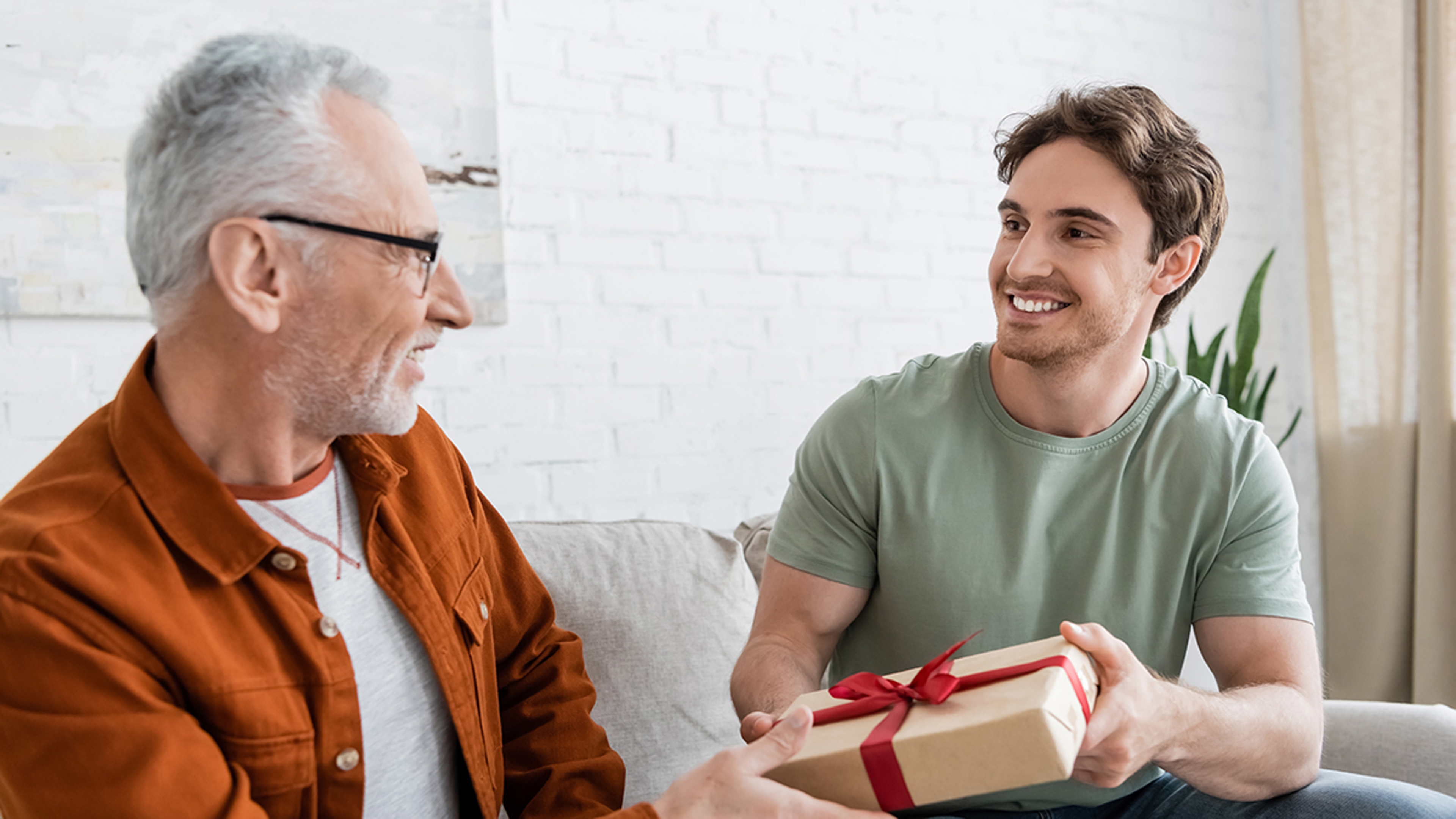 Article Cards Featured Image happy man congratulating dad on fathers day and giving him gift