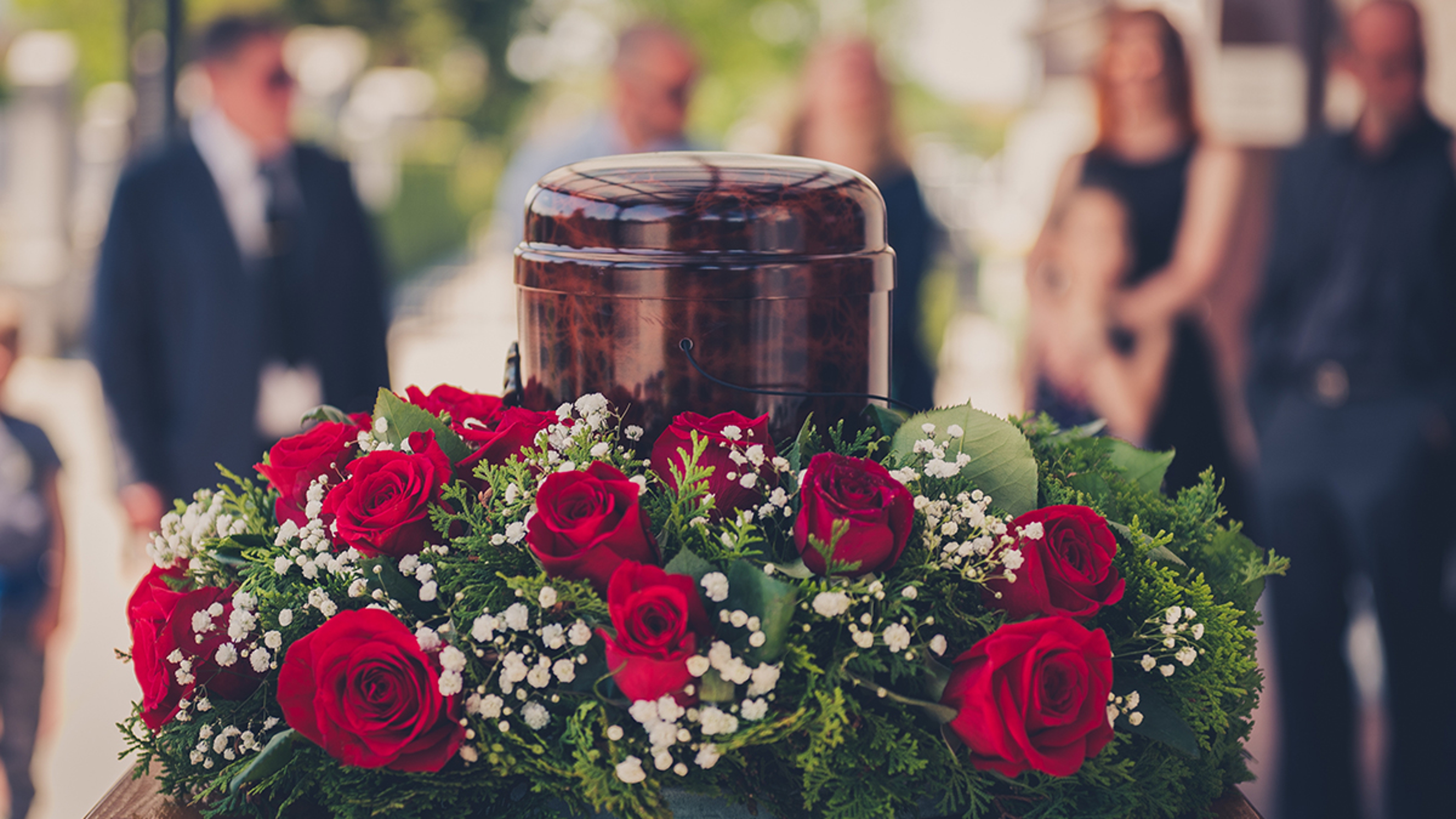 Article Cards Featured Image Funerary urn with ashes of dead and flowers at funeral.