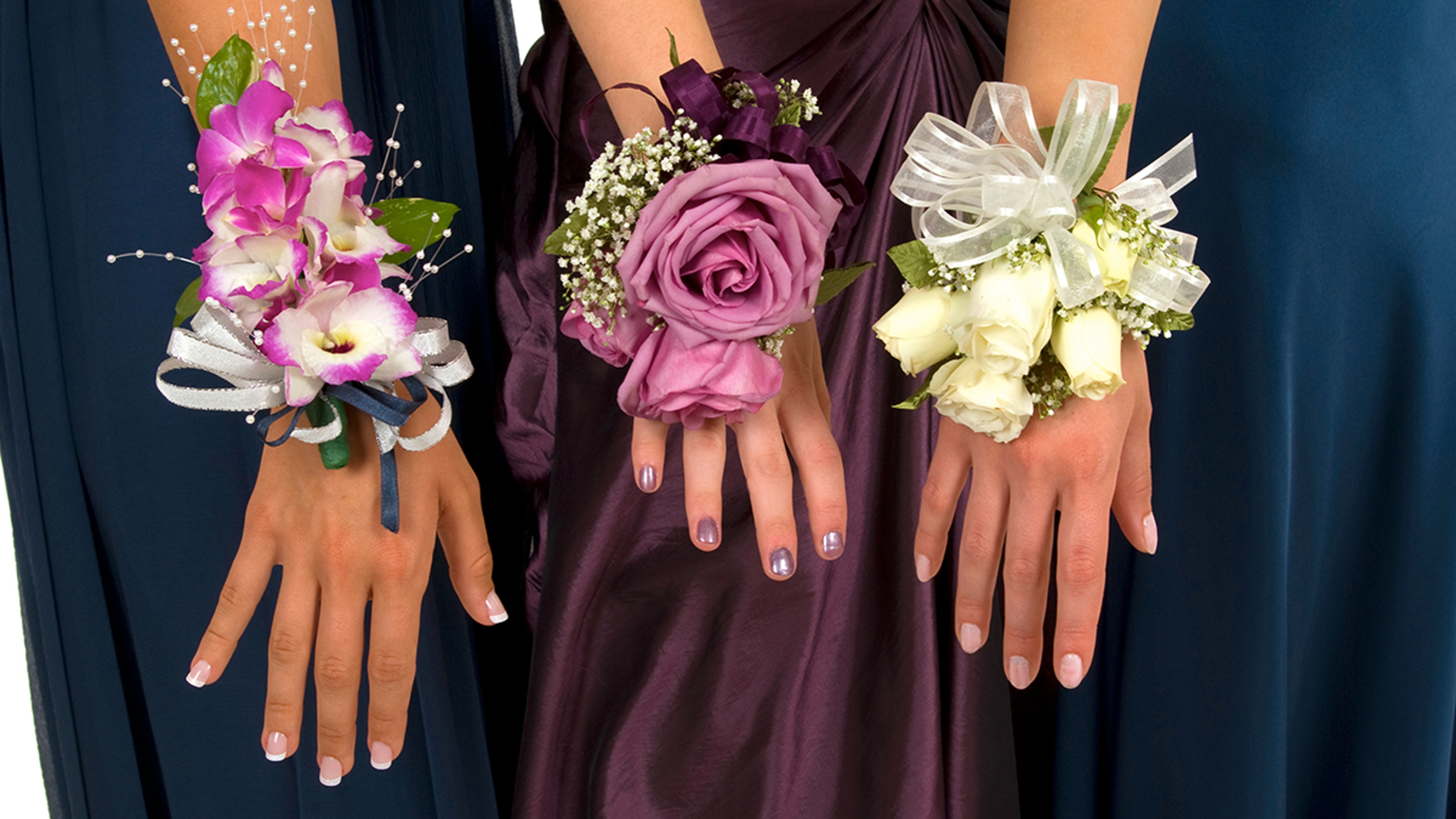 Girls showing their corsages to the camera.
