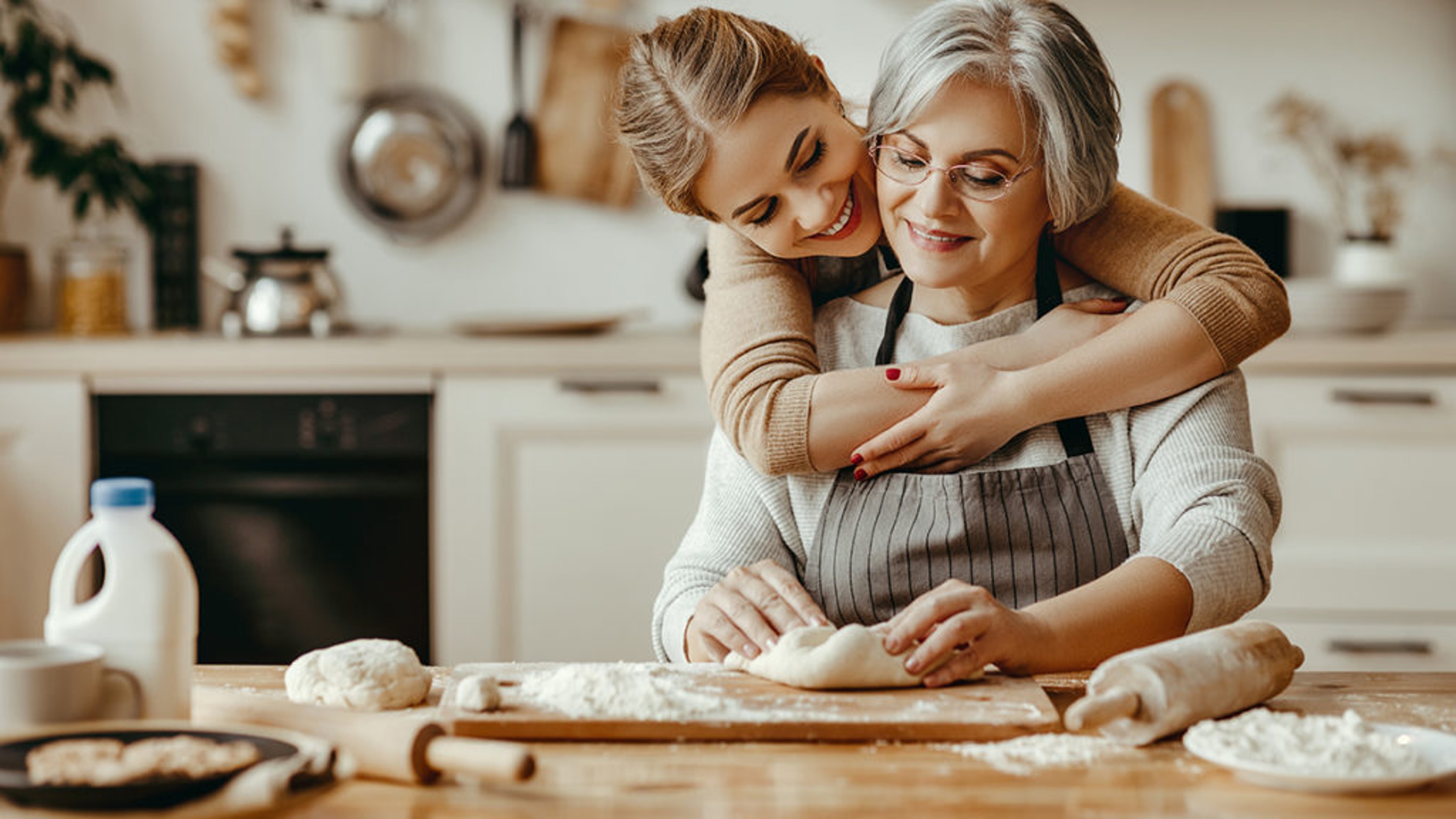 ways to show you care mother forming dough daughter giving her a hug from behind