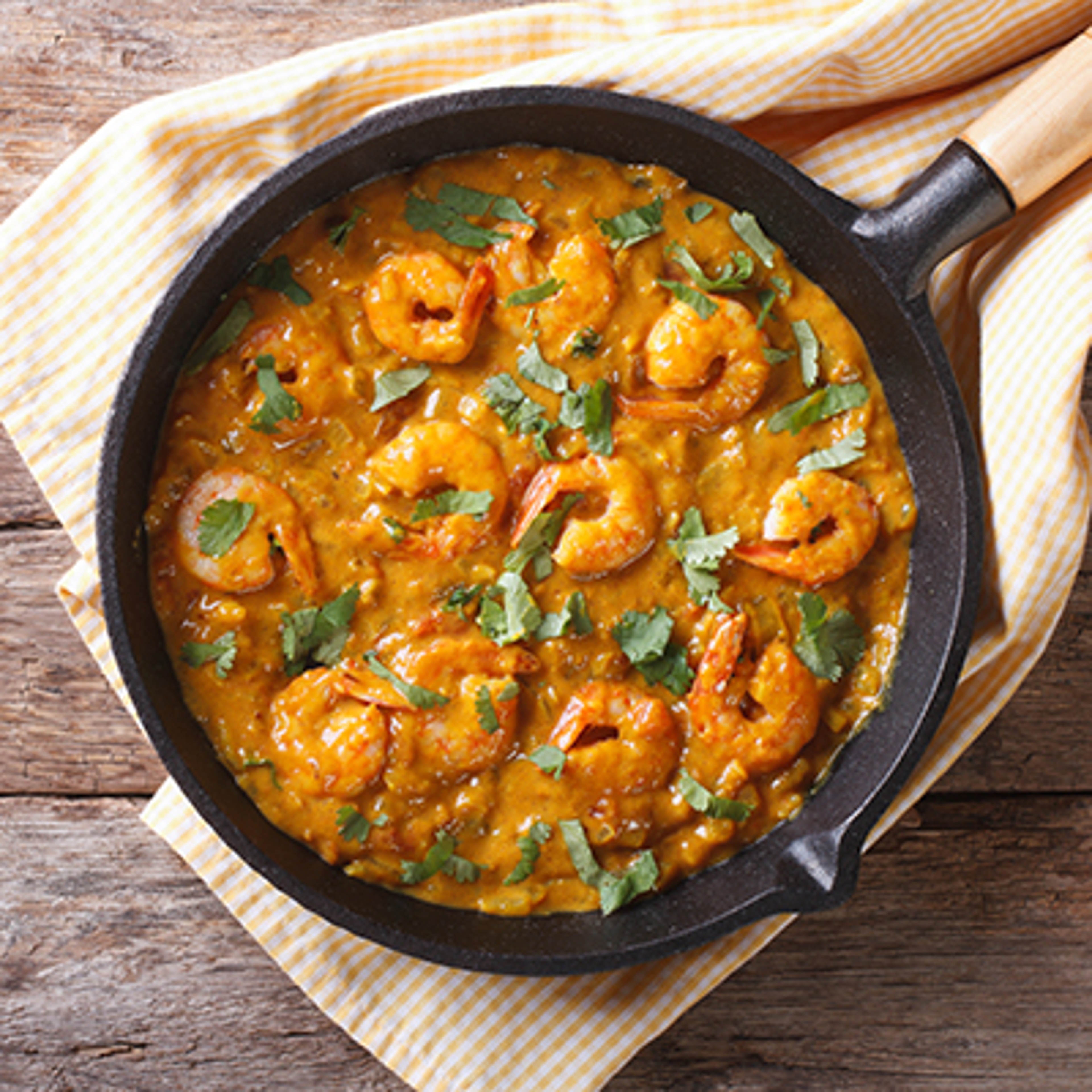 Shrimp in curry sauce in the pan. horizontal top view