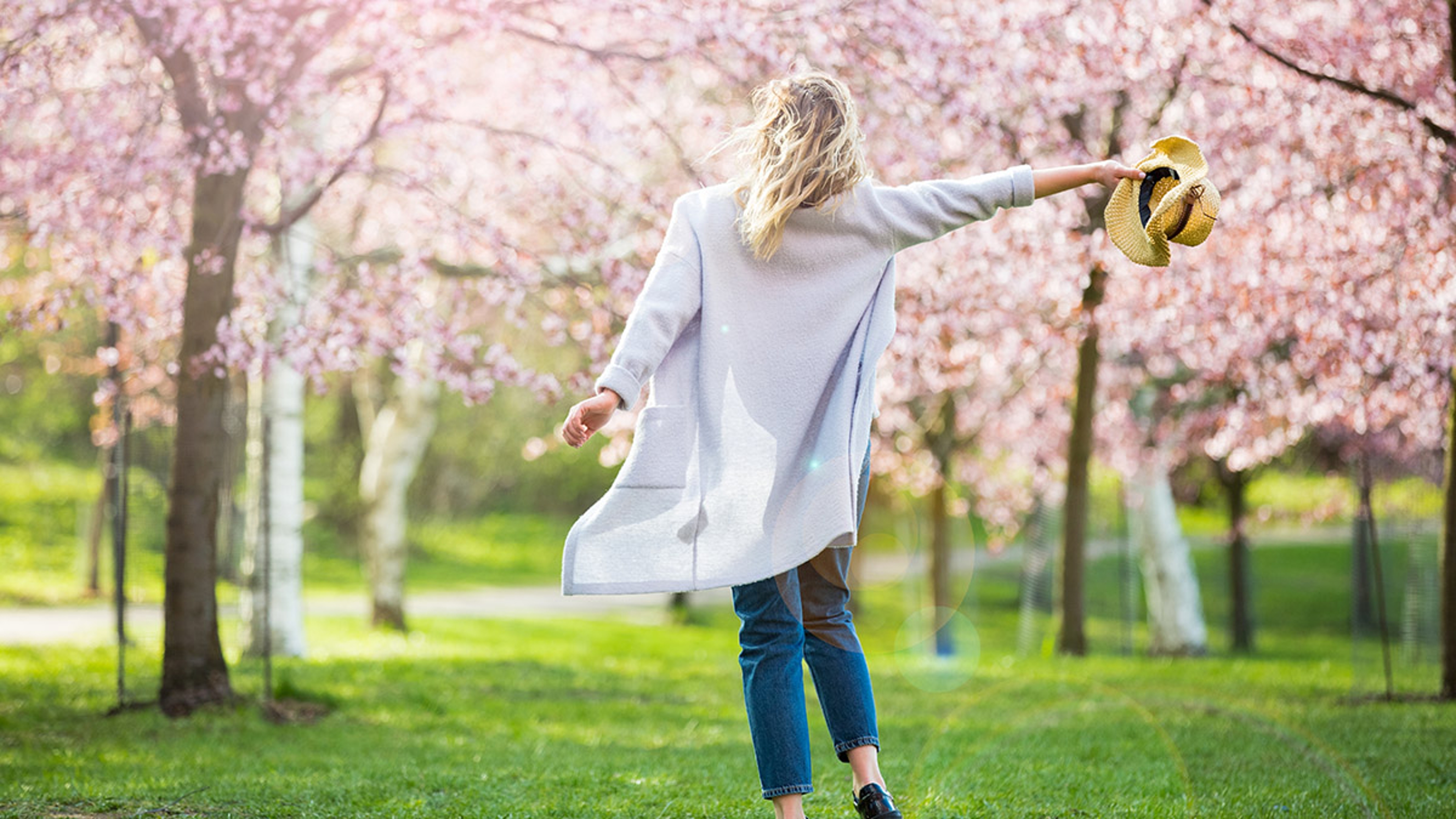 Article Cards Featured Image Young woman enjoying the nature in spring. Dancing, running and