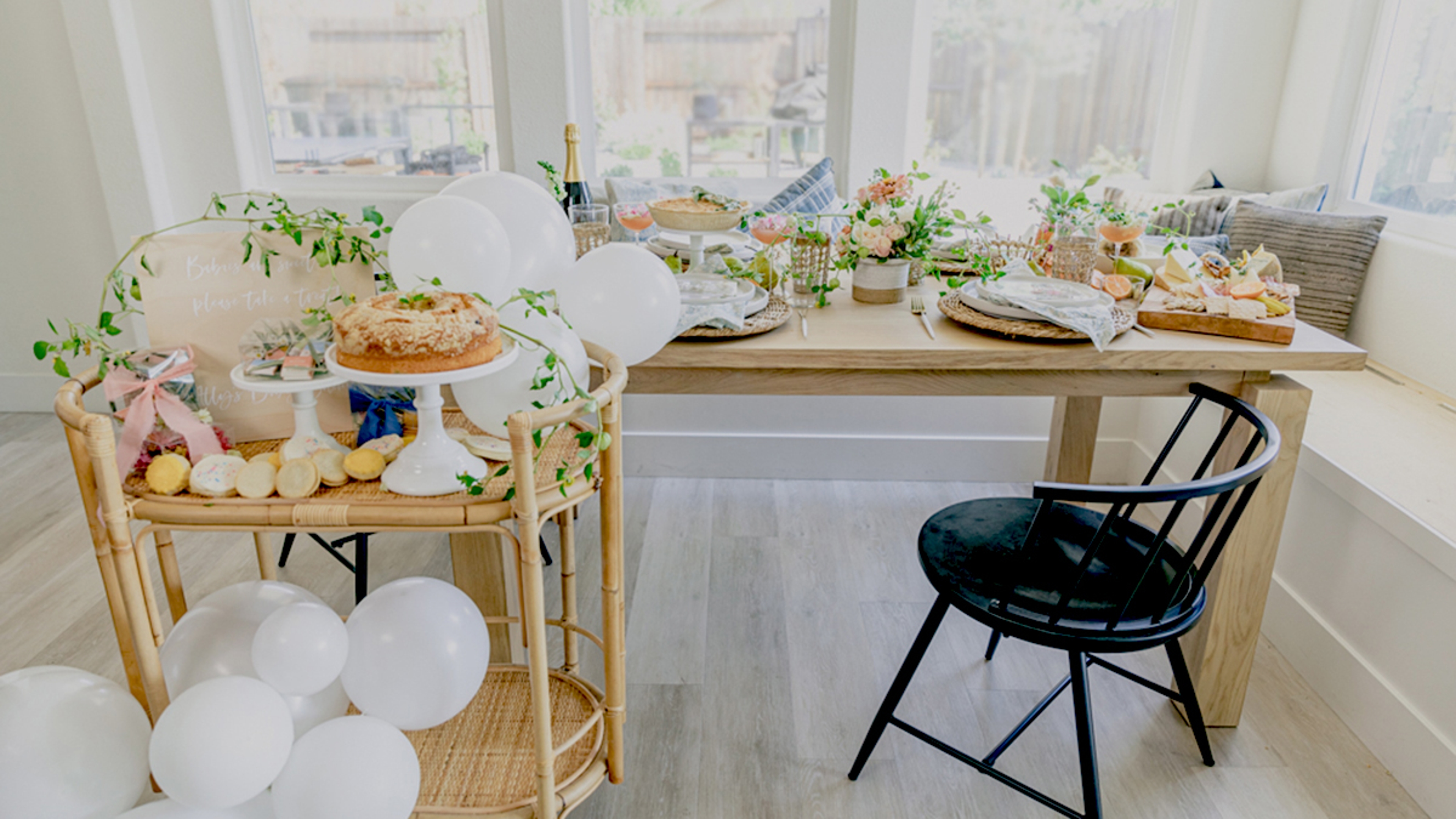 how to host a baby shower table with flowers, balloons, and food.