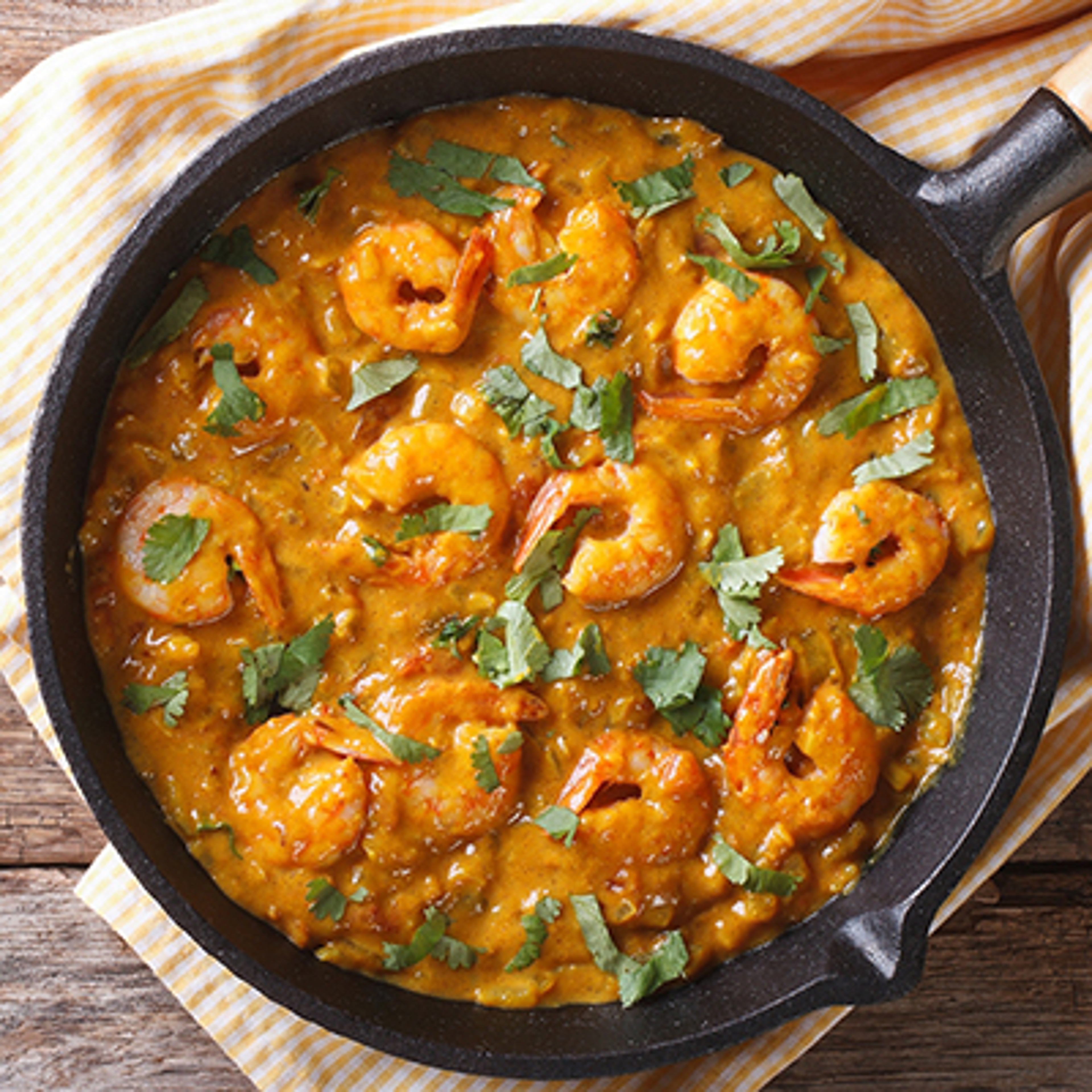 Cast iron skillet with shrimp and sauce.