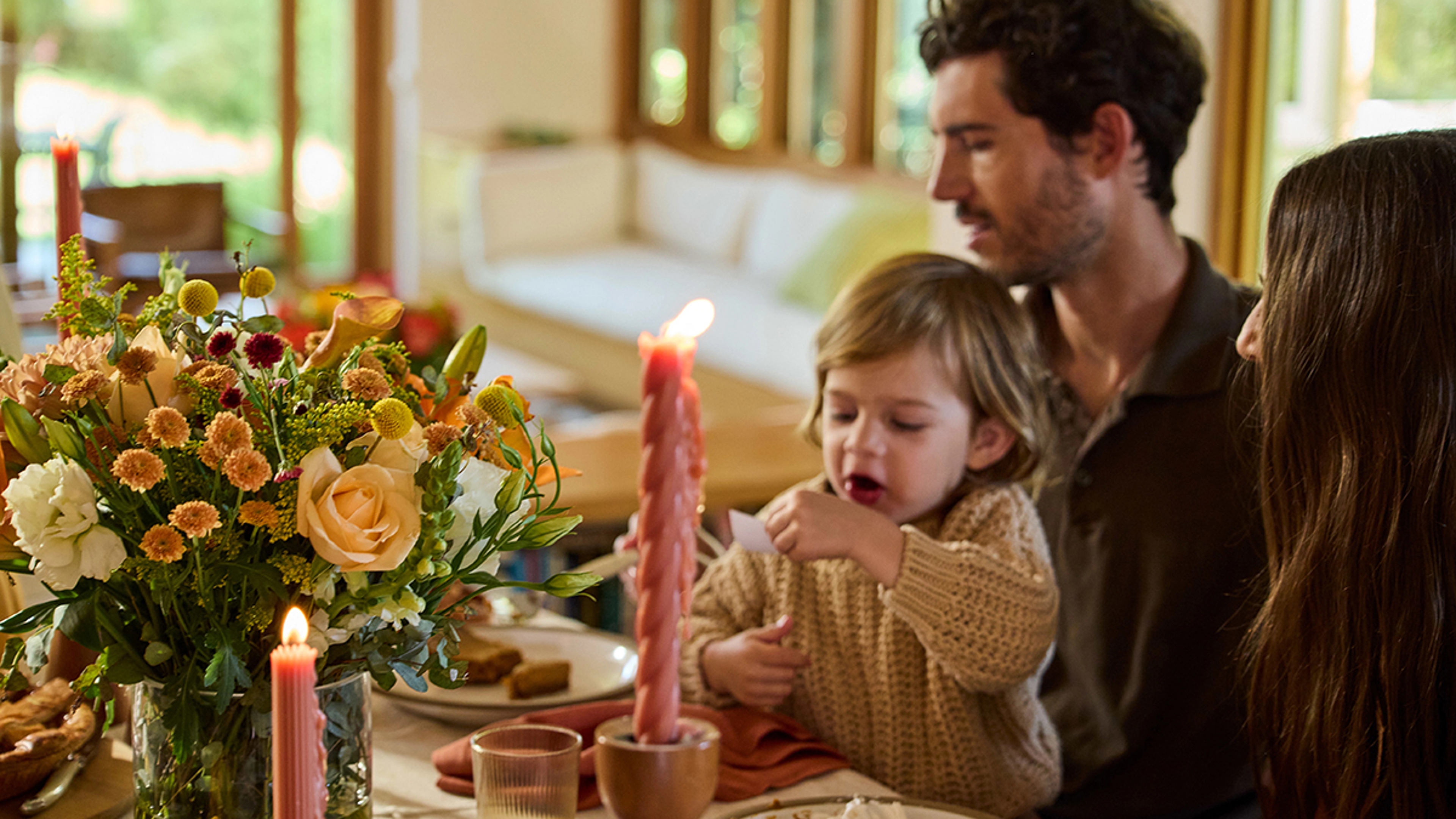 Family playing a Thanksgiving game at their table.