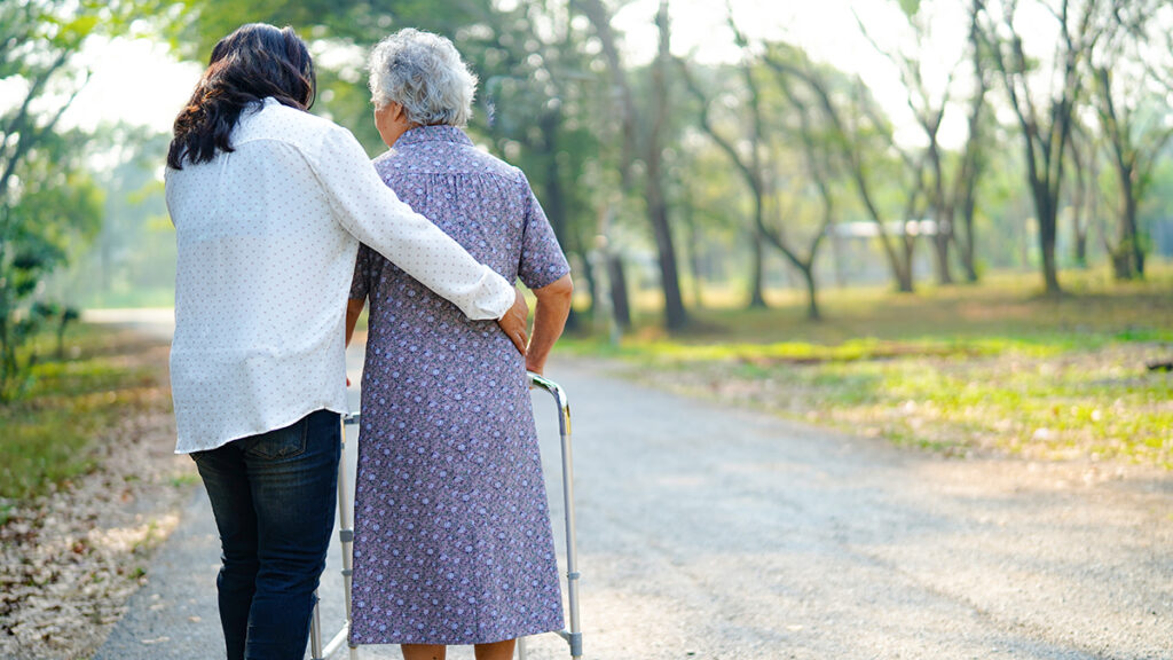 Caregiver walking with an older woman.