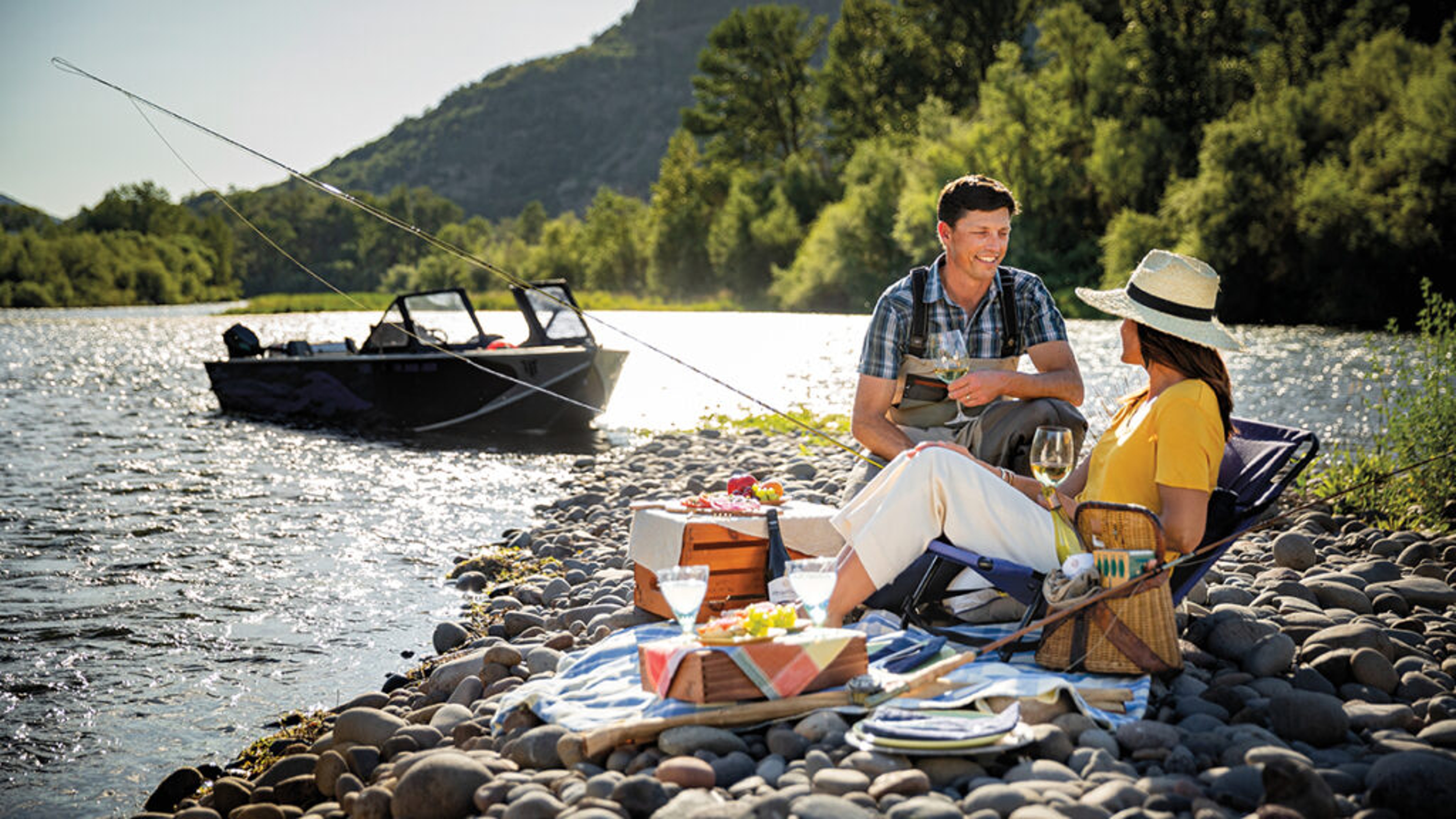 Reasons to love fish with a couple fishing on a river with a picnic.