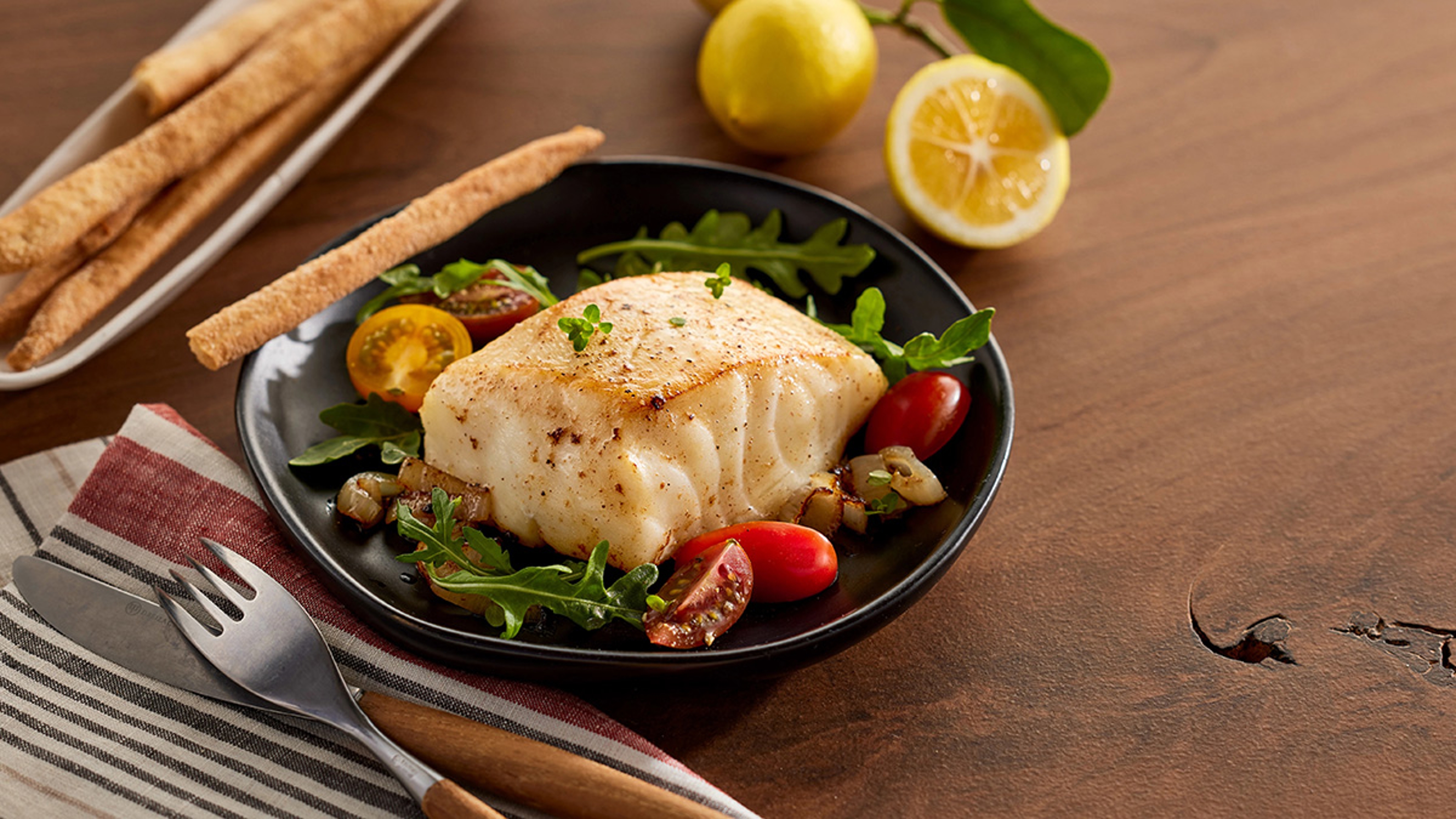 Filet of Chilean seabass plated with vegetables.