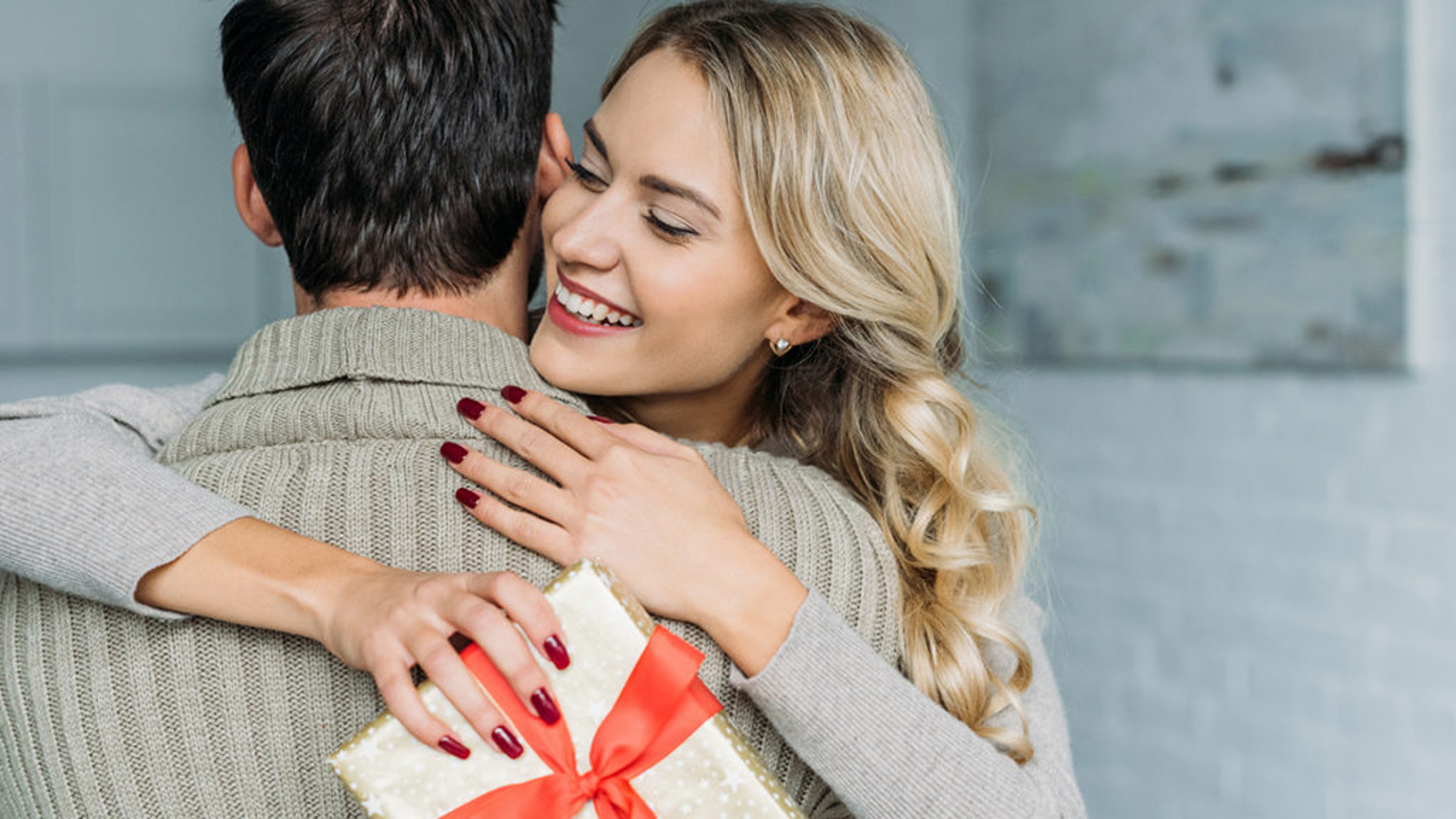 Woman hugging man who gave her a gift.