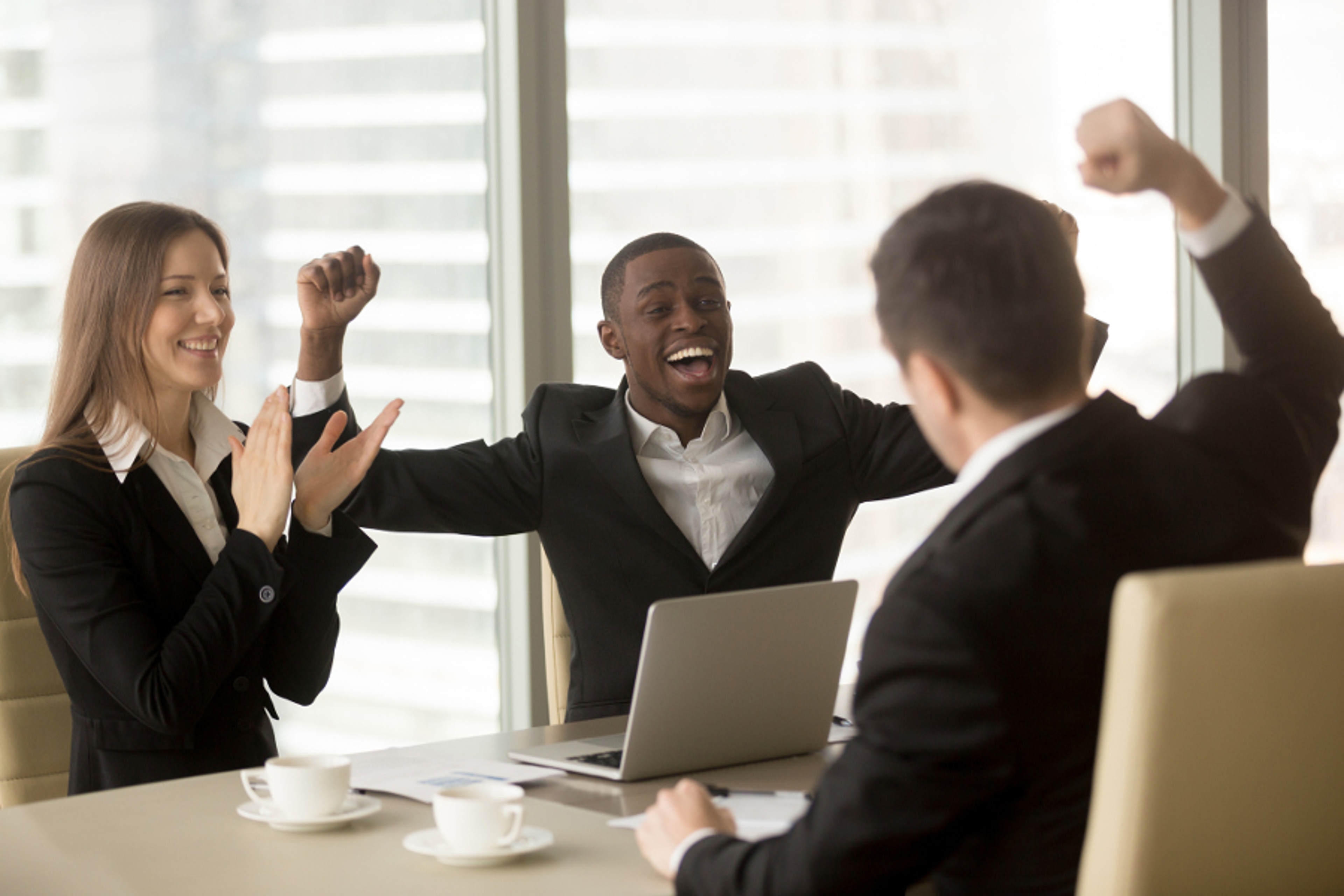 Article Cards Featured Image Happy excited multi ethnic business team in formal wear celebrating victory, raising hands and applauding, unexpected win, stock trading success, impressive achievement, great luck, yes we did it