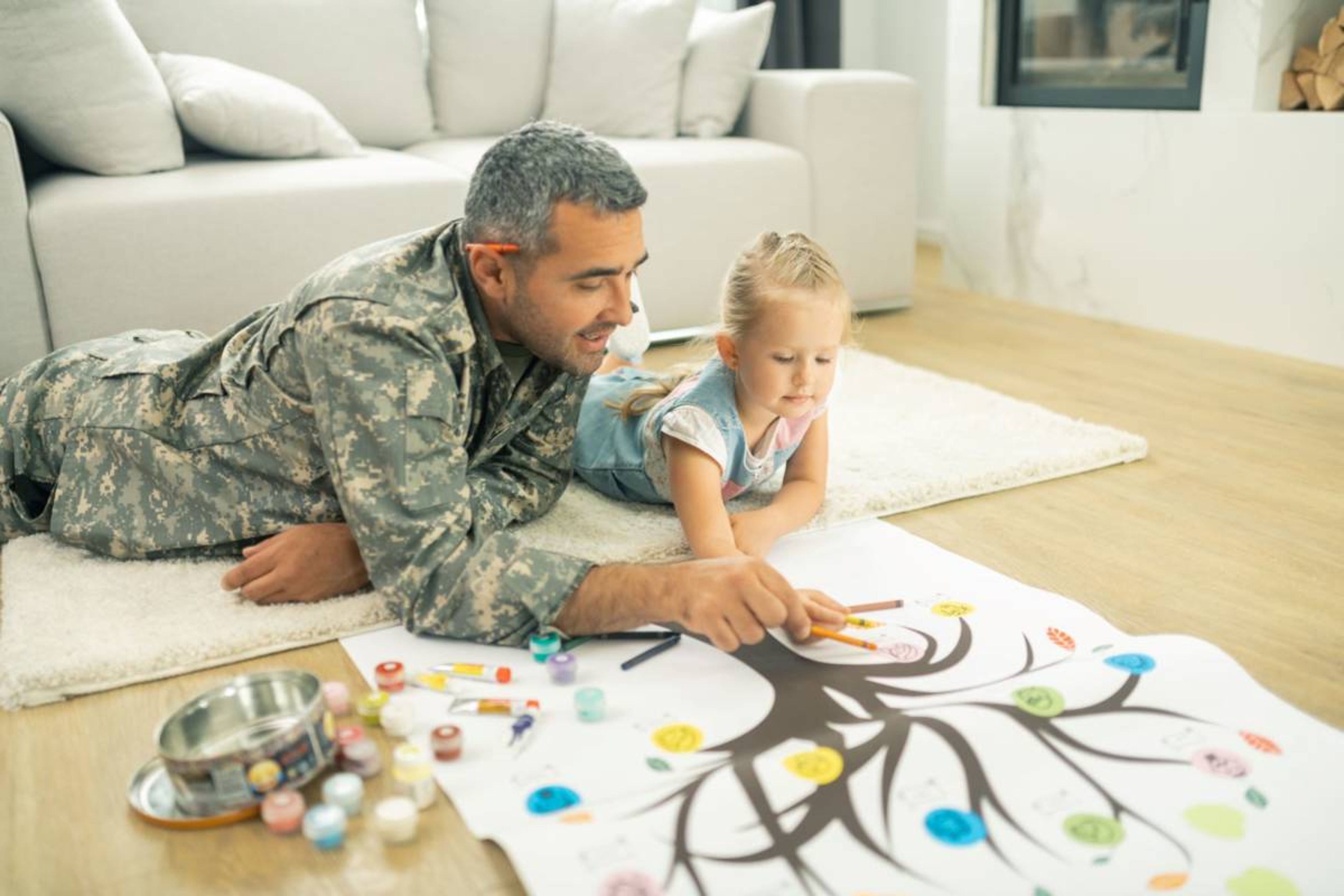 Man in military uniform filling in family tree with child