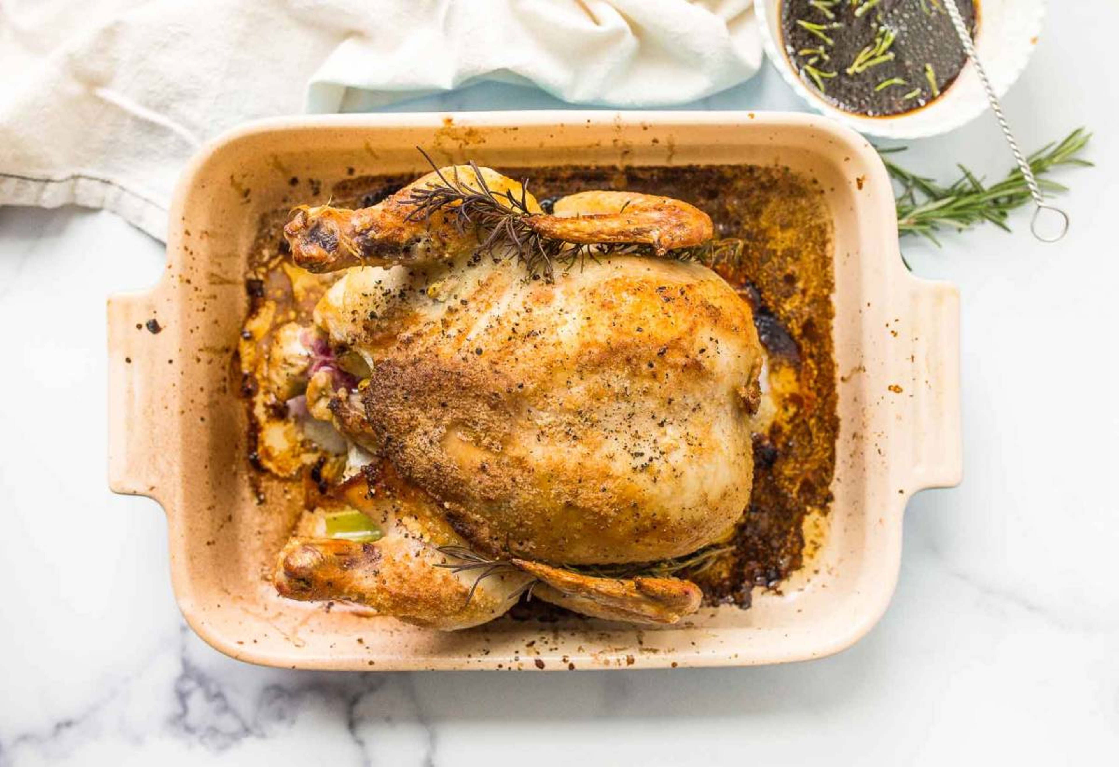 roasted chicken in a pan with herbs and spices