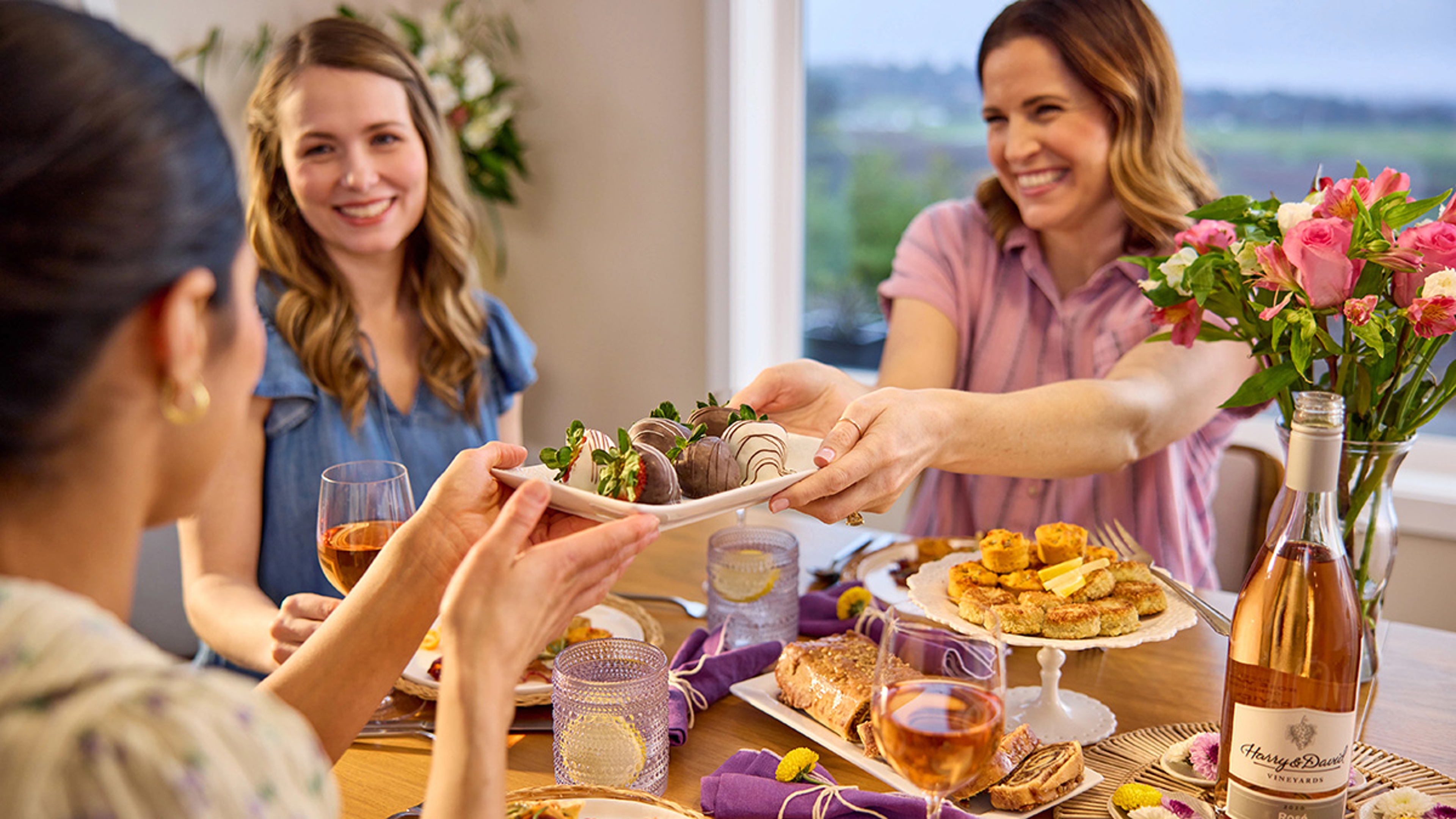 Group of women eating brunch and chocolate covered strawberries.