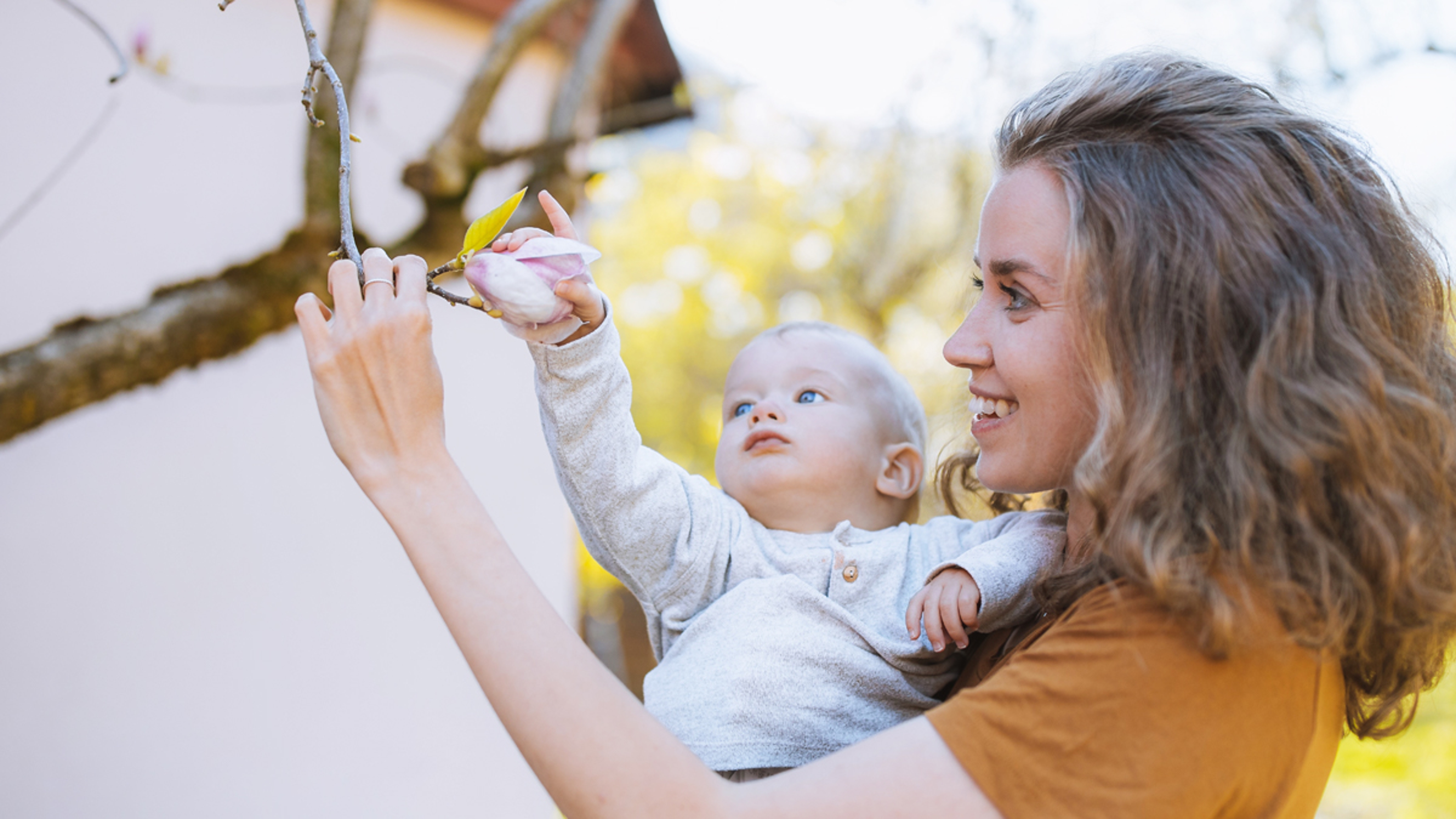 Mommy brain isn't bad it's one of the benefits of motherhood and another reason to celebrate moms. In this photo, a mom shows her baby a tree branch.